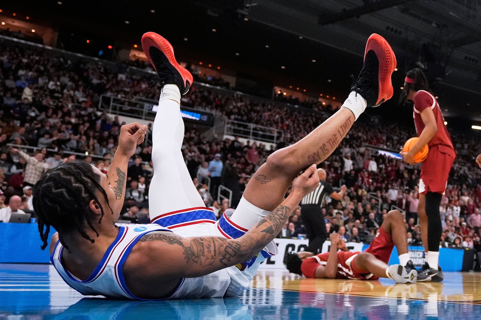 Kansas guard Shakeel Moore, left, lands on the floor after a collision with Arkansas forward Karter Knox during the first half in the first round of the NCAA college basketball tournament, Thursday, March 20, 2025, in Providence, R.I. (AP Photo/Charles Krupa)