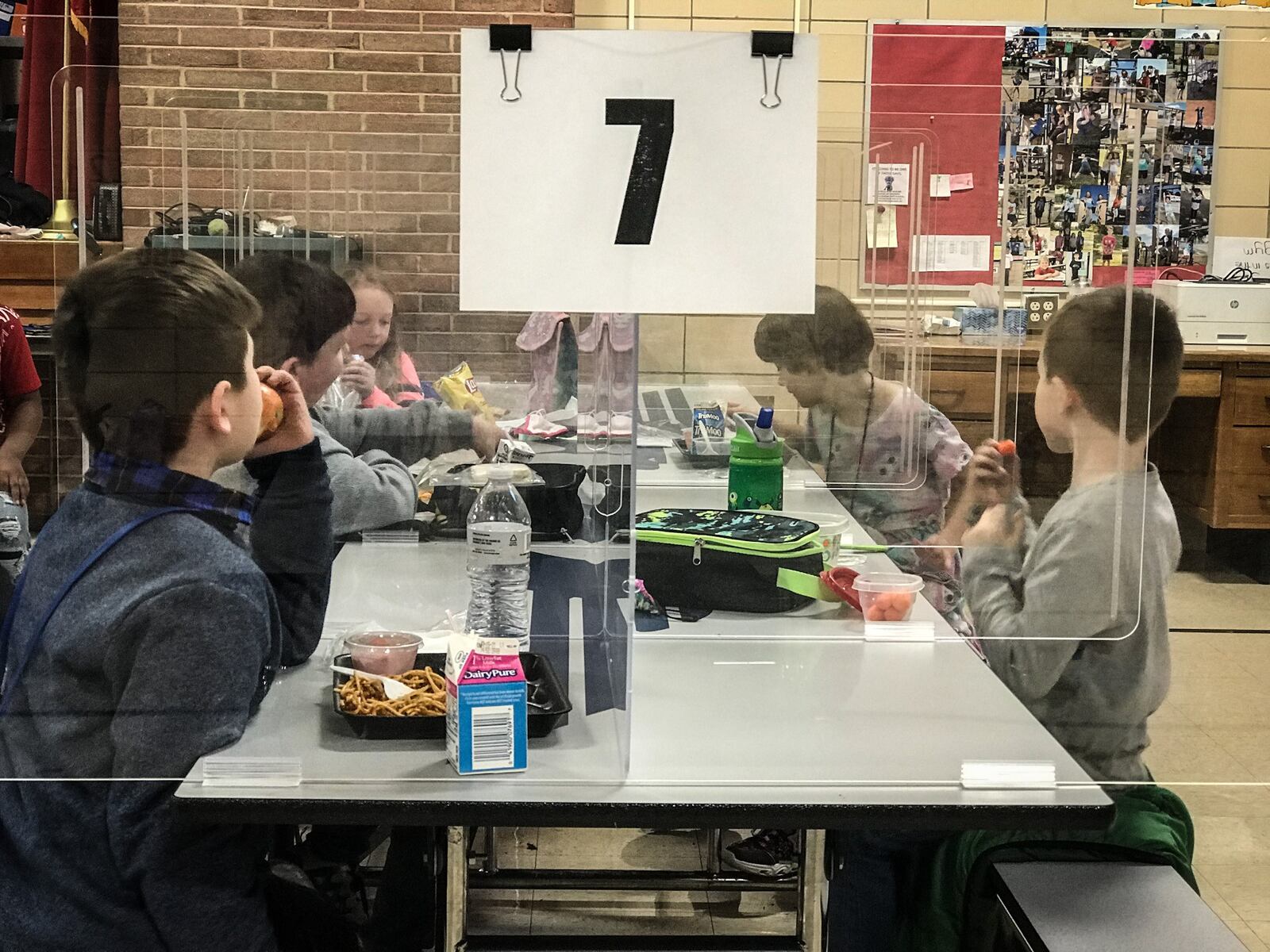 Students at Orchard Park Elementary School in Kettering eat lunch in plastic boxes because of COVID-10,.