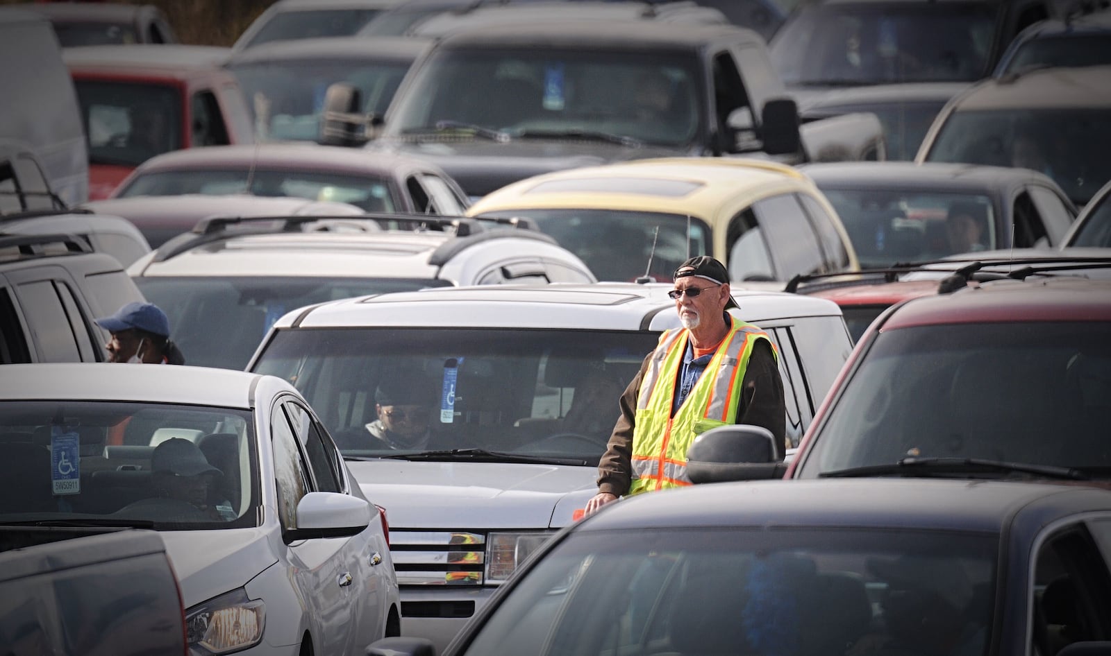 Vehicles lined up Thursday afternoon for a free turkey giveaway in the former Kroger parking lot on Needmore Avenue. The drive-thru giveaway is through With God's Grace Food Pantry. STAFF/MARSHALL GORBY