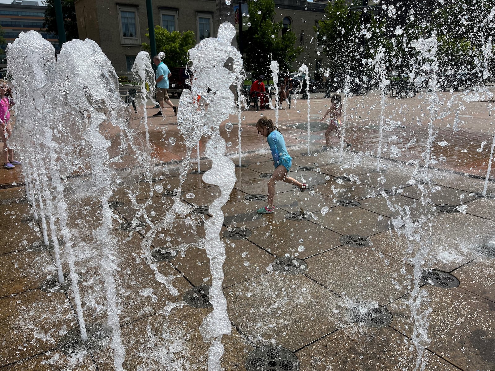 A young girl plays in the fountain at RiverScape MetroPark in downtown Dayton on Sunday, July 9, 2023. CORNELIUS FROLIK / STAFF