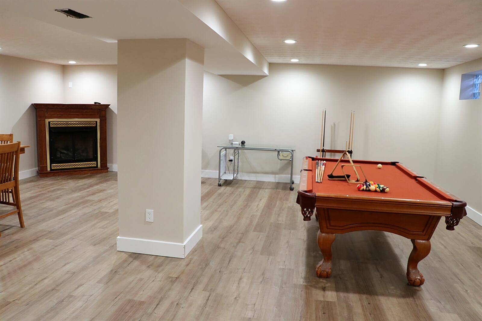 The basement has been finished into a recreation room and game room with a corner gas fireplace. The basement has wood-laminate flooring, recessed lighting and window wells. Off the game room is a door that opens to a half bathroom. CONTRIBUTED PHOTO BY KATHY TYLER