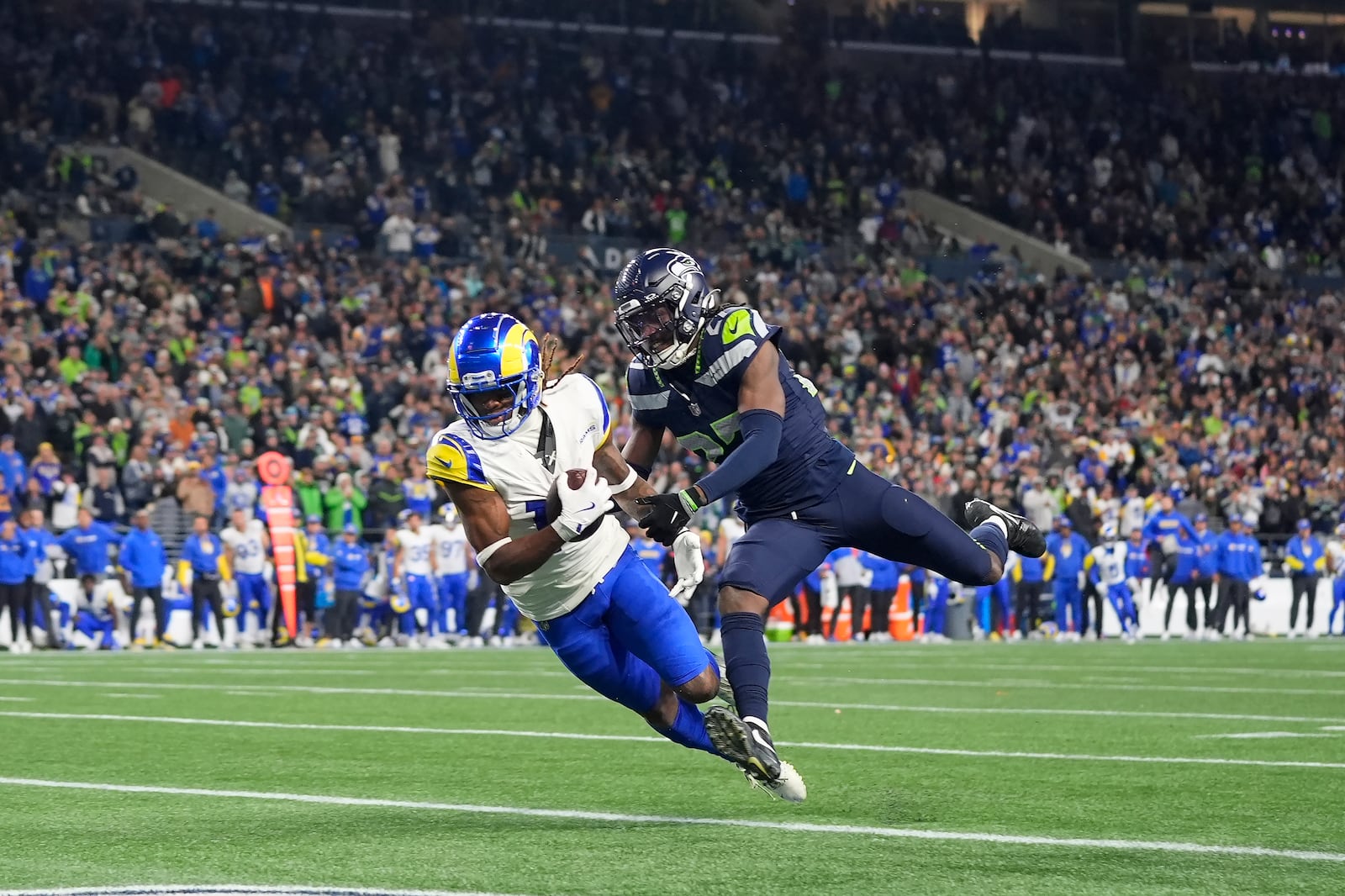 Los Angeles Rams wide receiver Demarcus Robinson, left, catches a touchdown pass against Seattle Seahawks cornerback Riq Woolen during overtime of an NFL football game in Seattle, Sunday, Nov. 3, 2024. (AP Photo/Lindsey Wasson)