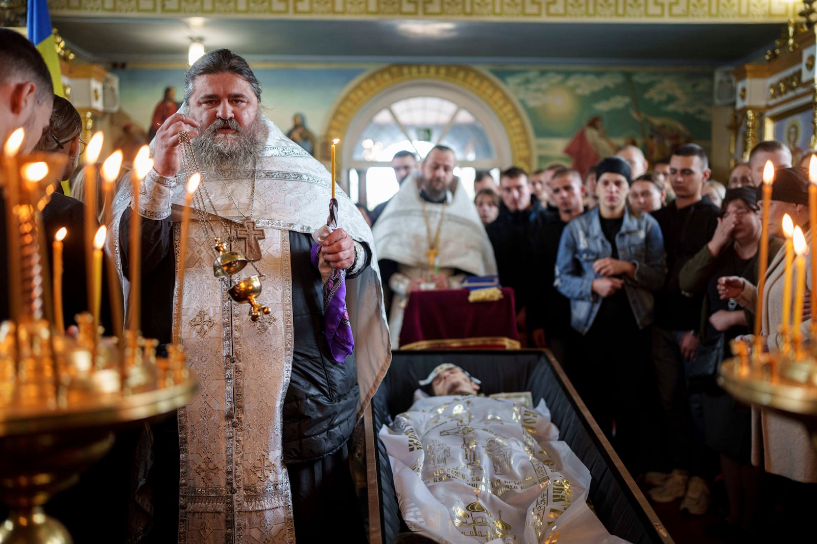 FILE - A priest reads a prayer for a fallen Ukrainian solfer fIhor Kusochek during the funeral ceremony in Bobrovytsia, Chernihiv region, Ukraine, on Oct. 4, 2024. (AP Photo/Evgeniy Maloletka, File)