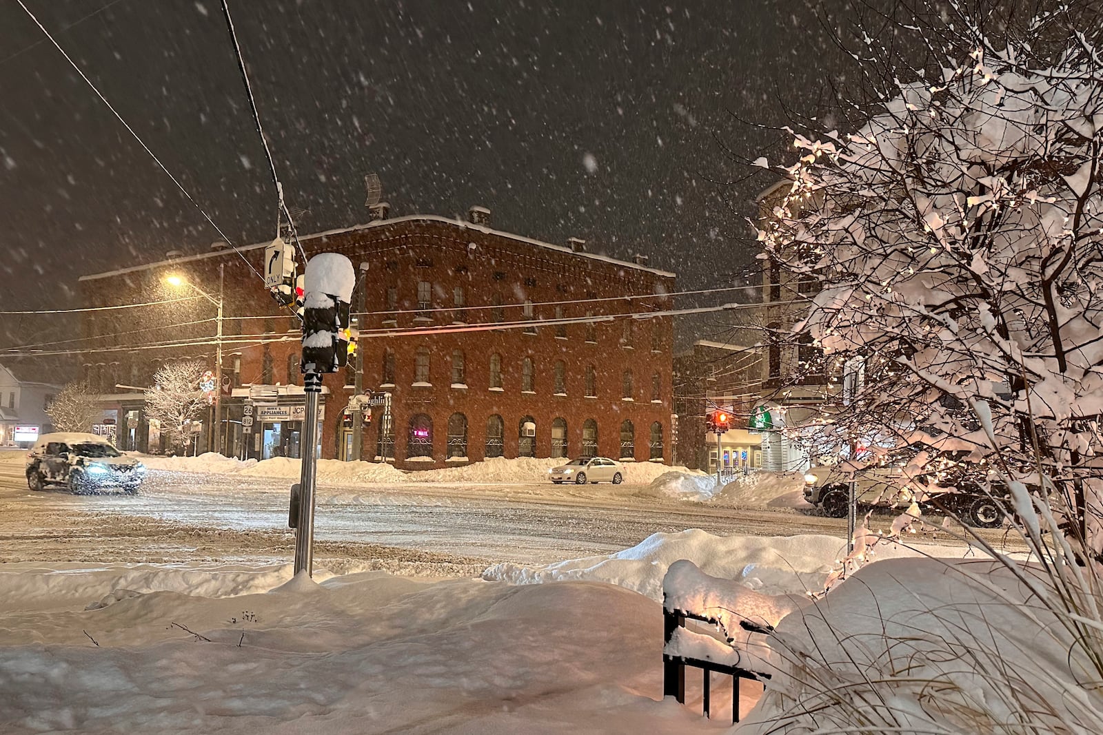 Traffic crawls as snow falls in Lowville, N.Y., on Sunday, Dec. 1. (AP Photo/Cara Anna)