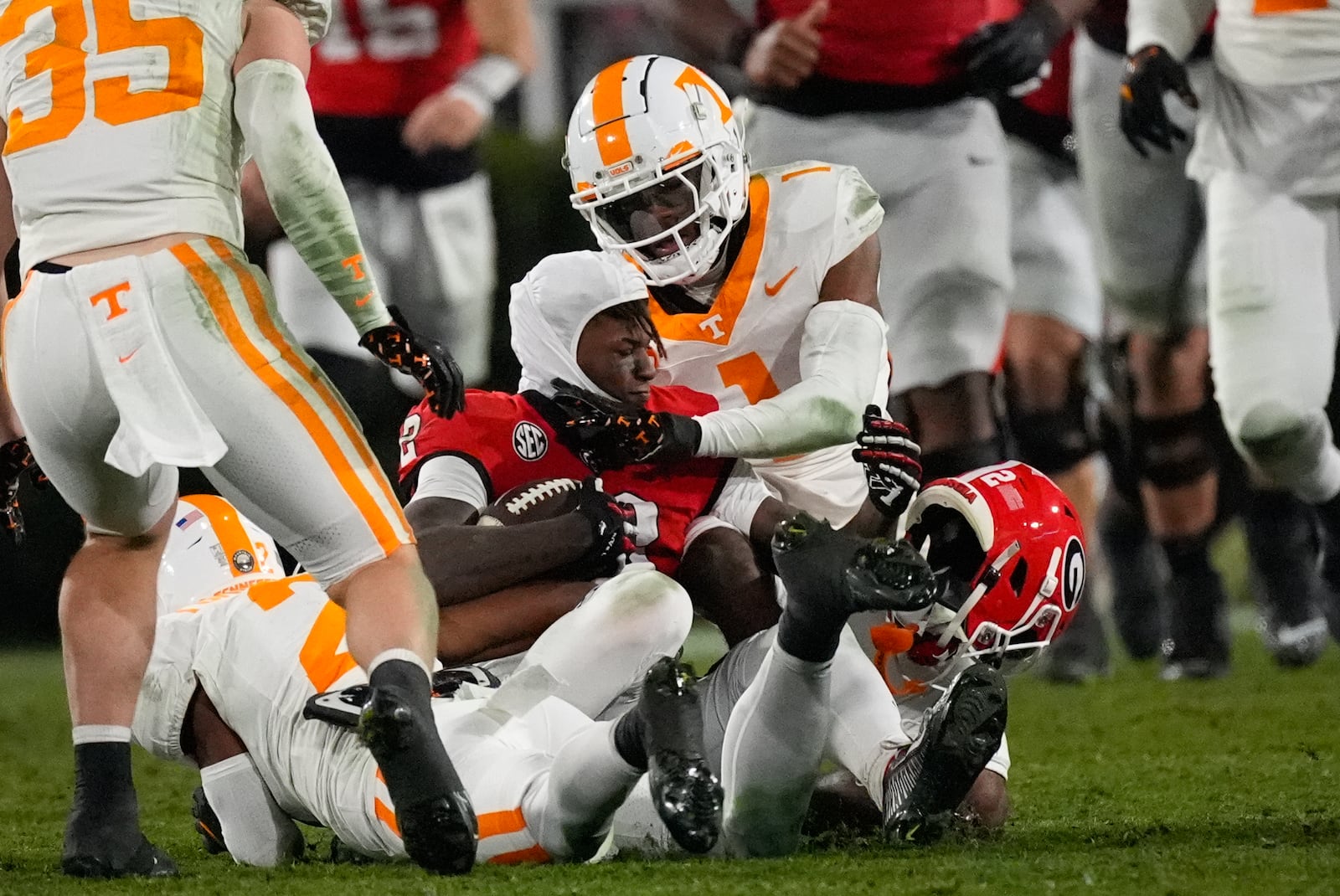 Georgia wide receiver Nitro Tuggle (2) loses his helmet as he is tackled by Tennessee defensive back Andre Turrentine (2) during the second half of an NCAA college football game, Saturday, Nov. 16, 2024, in Athens, Ga. (AP Photo/John Bazemore)