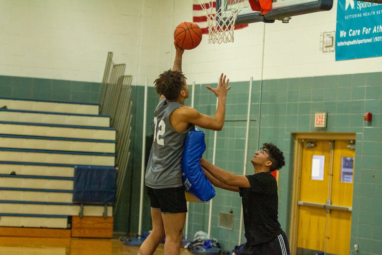 Fairmont student coach Jordan Harbeck assists with a drill, helping senior Dasan Doucet finish through contact. Harbeck works with the team at practice, breaks down film with the players and sits on the bench during games. Jeff Gilbert/CONTRIBUTED