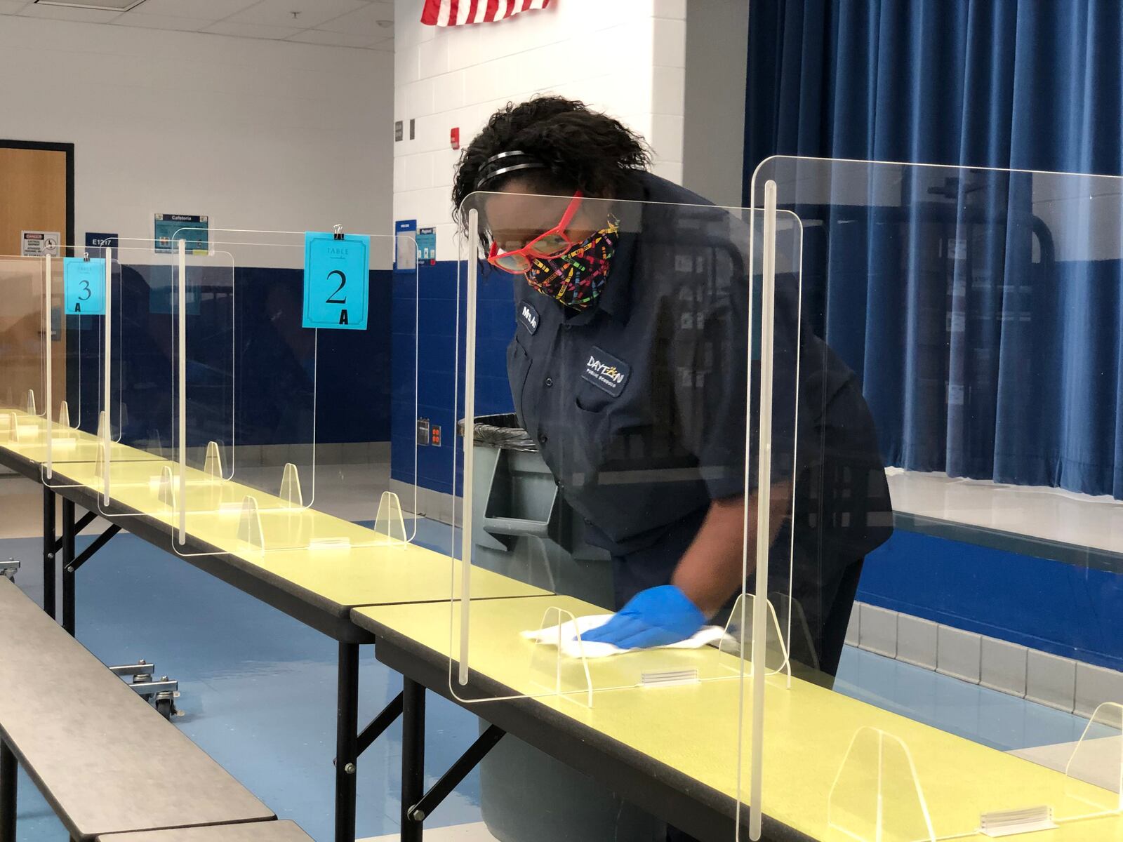 Dayton Public Schools staff work to keep cafeteria tables clean and sanitized at River's Edge Montessori School in November 2020. CONTRIBUTED PHOTO