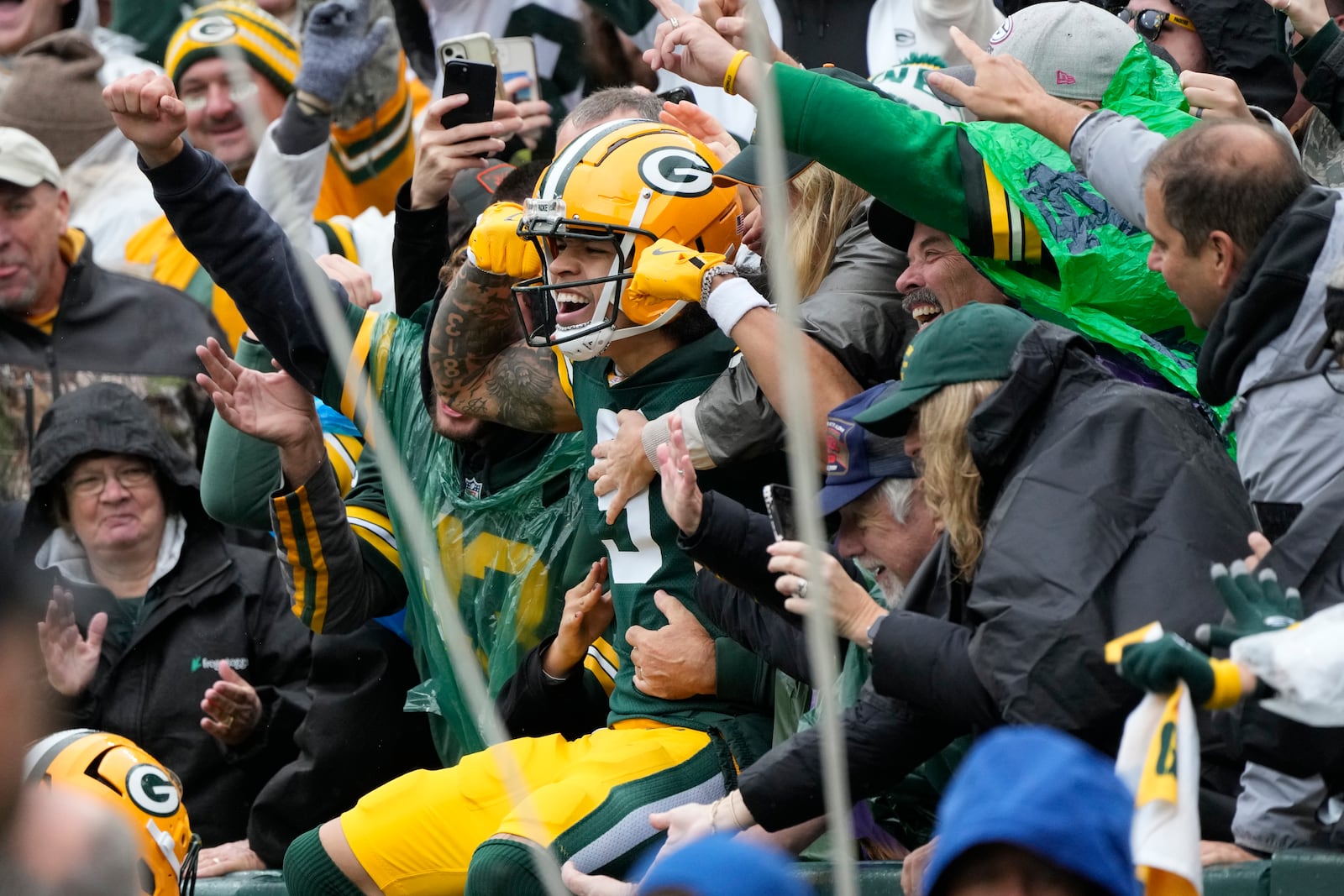 Green Bay Packers wide receiver Christian Watson celebrates with fans after his 44-yard reception for a touchdown during the first half of an NFL football game against the Arizona Cardinals, Sunday, Oct. 13, 2024, in Green Bay. (AP Photo/Morry Gash)