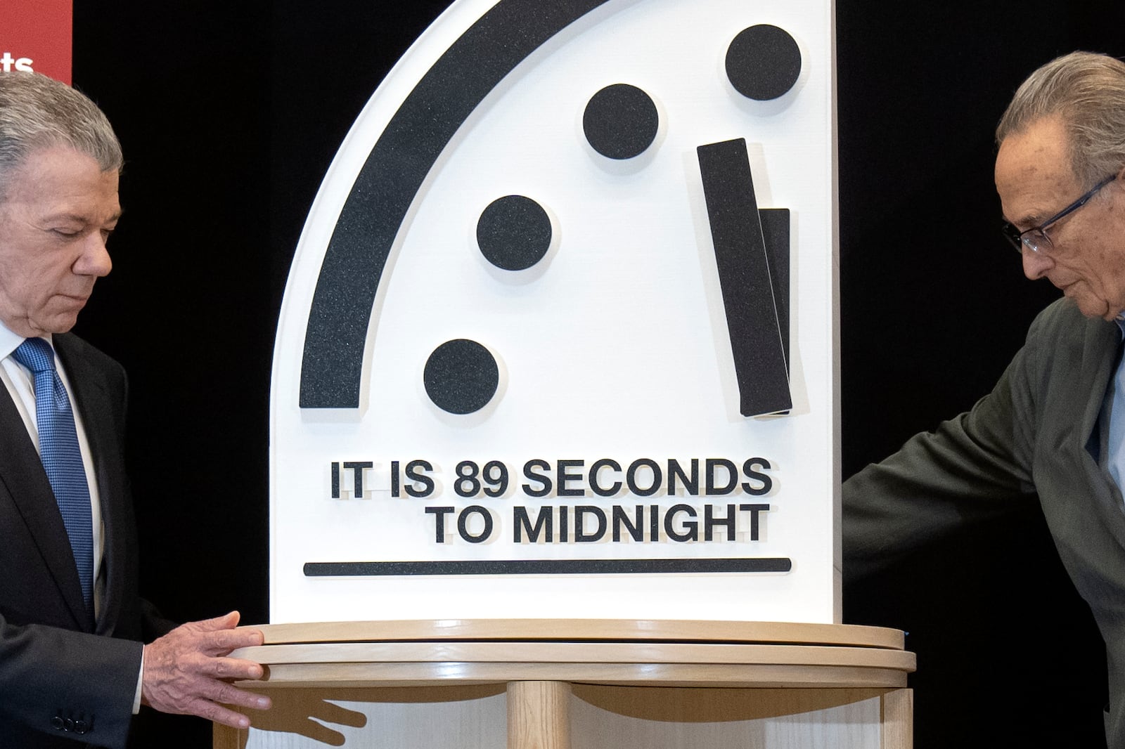 Former Colombian President Juan Manuel Santos, left, and Bulletin of the Atomic Scientists member Robert Socolow reveal the Doomsday Clock, set at 89 seconds to midnight, during a news conference at the United States Institute of Peace, Tuesday, Jan. 28, 2025, in Washington. (AP Photo/Mark Schiefelbein)