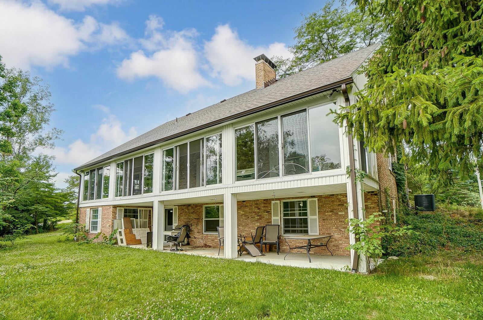 The rear of the home has a walkout basement with covered patio and a main-level covered balcony with sliding glass doors.