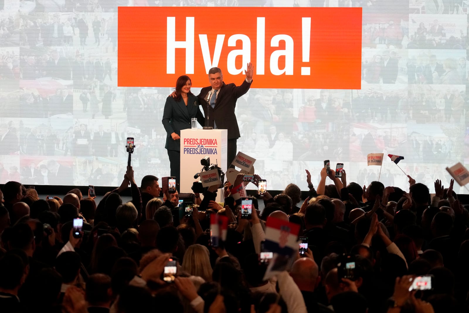 President incumbent Zoran Milanovic with his wife Sanja Music Milanovic greets his supporters as the preliminary results grant him victory in a runoff vote for the Croatian presidential election in Zagreb, Croatia, Sunday, Jan. 12, 2025. The sign reads "Thank You". (AP Photo/Darko Bandic)