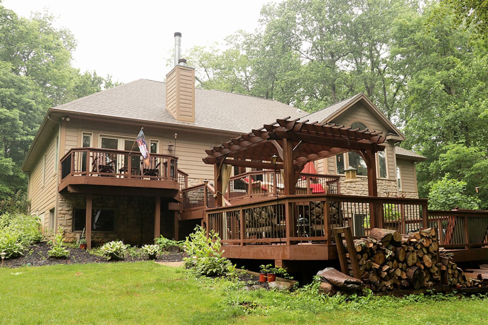 Glass doors in the great room are flanked by tall sidelight windows open to a multi-level wooden deck that has a built-in hot tub and pergola. Steps lead down to a gravel walkway that wraps up to the driveway. CONTRIBUTED PHOTO BY KATHY TYLER