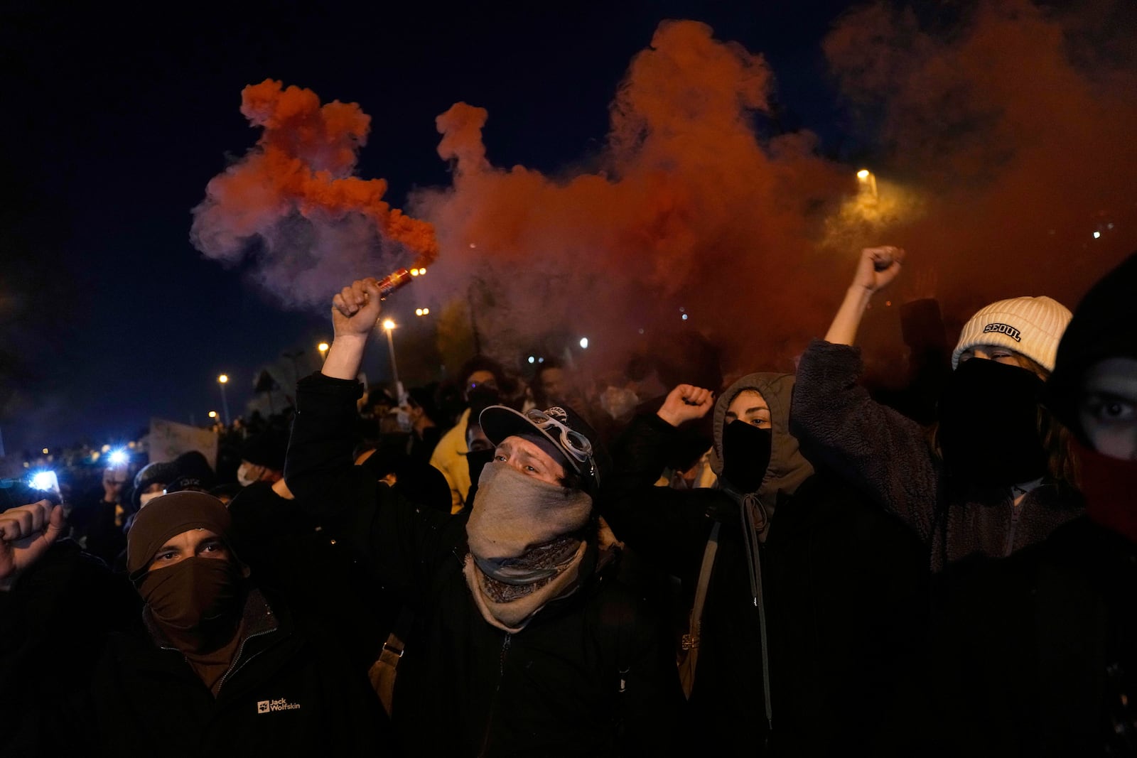 People light flares as they protest against the arrest of Istanbul's Mayor Ekrem Imamoglu, in Istanbul, Turkey, Friday, March 21, 2025. (AP Photo/Khalil Hamra)