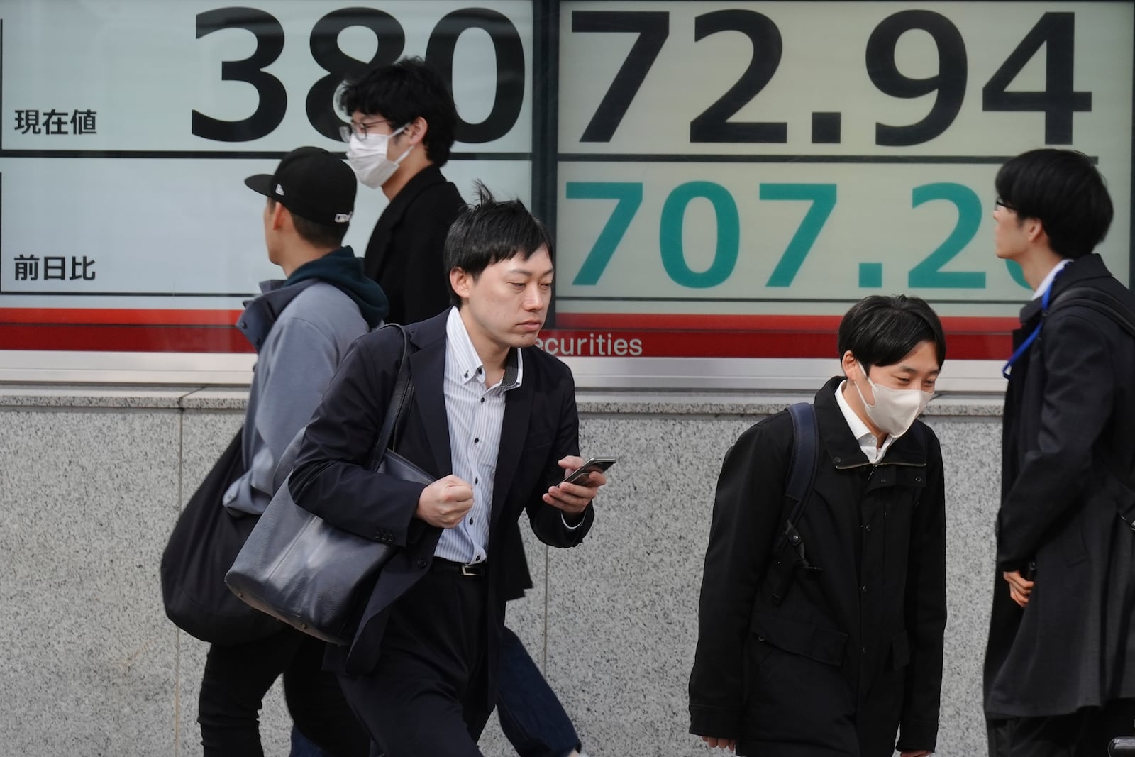 People walk in front of an electronic stock board showing Japan's Nikkei index at a securities firm Tuesday, Nov. 26, 2024, in Tokyo. (AP Photo/Eugene Hoshiko)