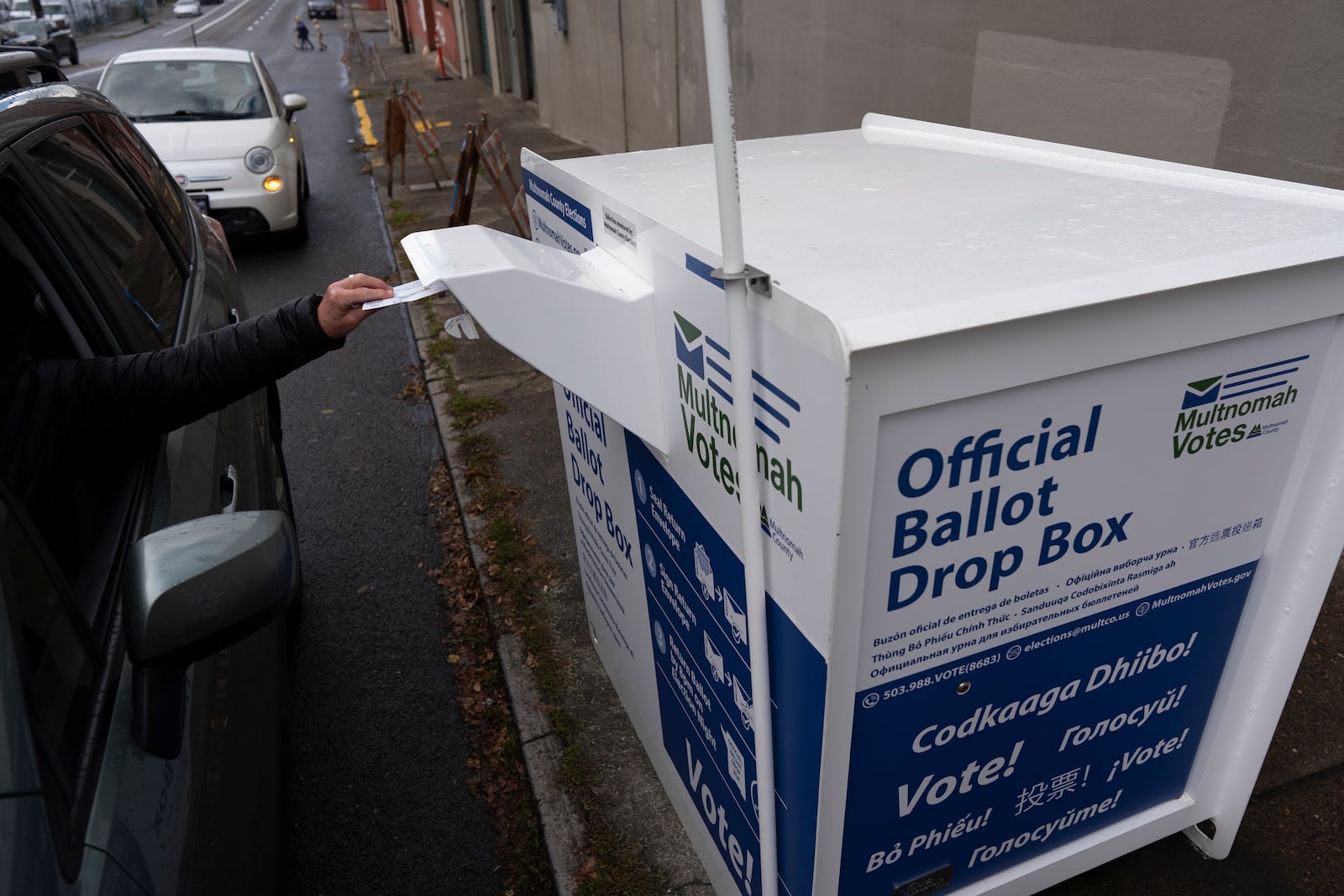 A person drops off their 2024 election ballot at a newly installed drop box outside the Multnomah County Elections Division office on Monday, Oct. 28, 2024, in Portland, Ore. (AP Photo/Jenny Kane)