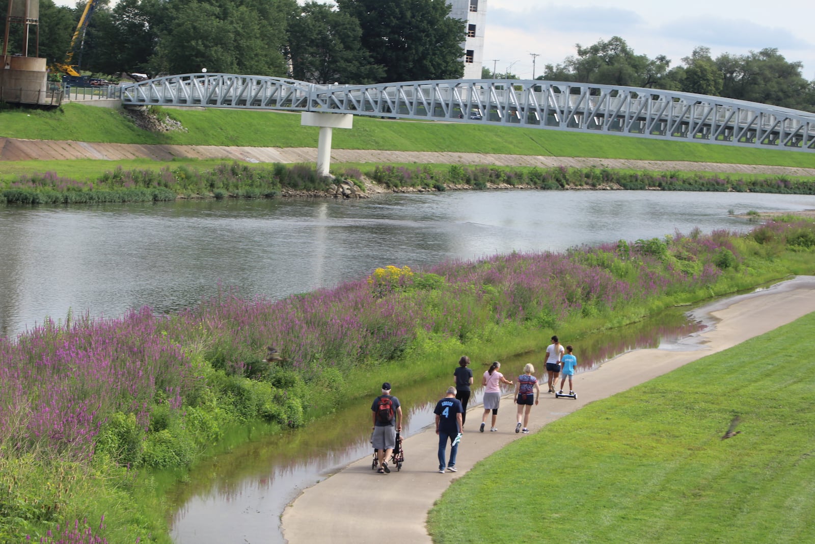 People walk along the river at RiverScape MetroPark in downtown Dayton. CORNELIUS FROLIK / STAFF