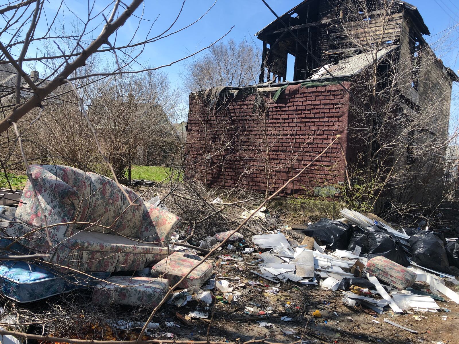 Trash litters a vacant and fire-damaged property in Dayton. CORNELIUS FROLIK / STAFF