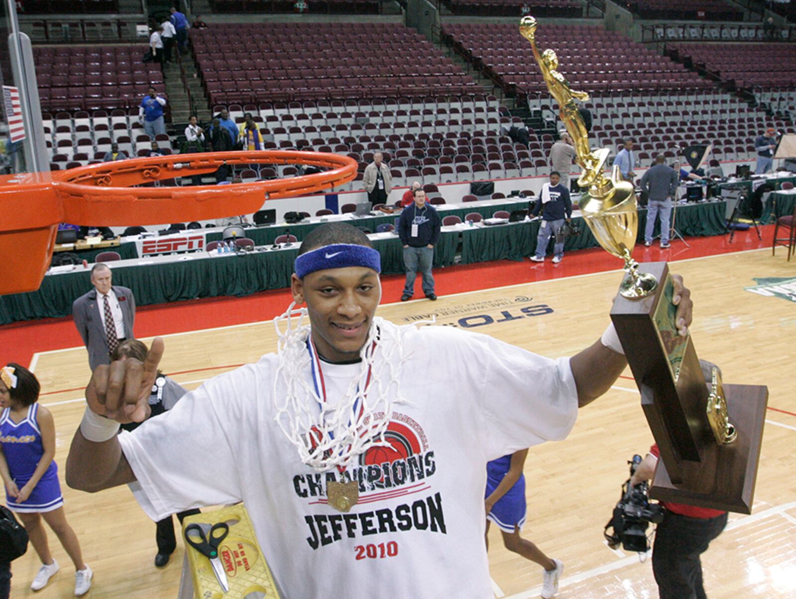 Adreian Payne, of Jefferson, has just cut a part of the basketball net and wrapped it around his neck all while holding the championship trophy. Dayton Jefferson played and defeated Newark Catholic, in the Division IV state championship basketball game, by the score of 59 to 52. Payne scored 11 points and collected 9 rebounds.