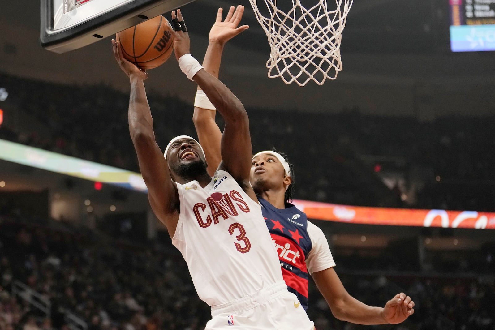 Cleveland Cavaliers guard Caris LeVert (3) shoots in front of Washington Wizards guard Bilal Coulibaly, right, in the first half of an NBA basketball game, Friday, Dec. 13, 2024, in Cleveland. (AP Photo/Sue Ogrocki)