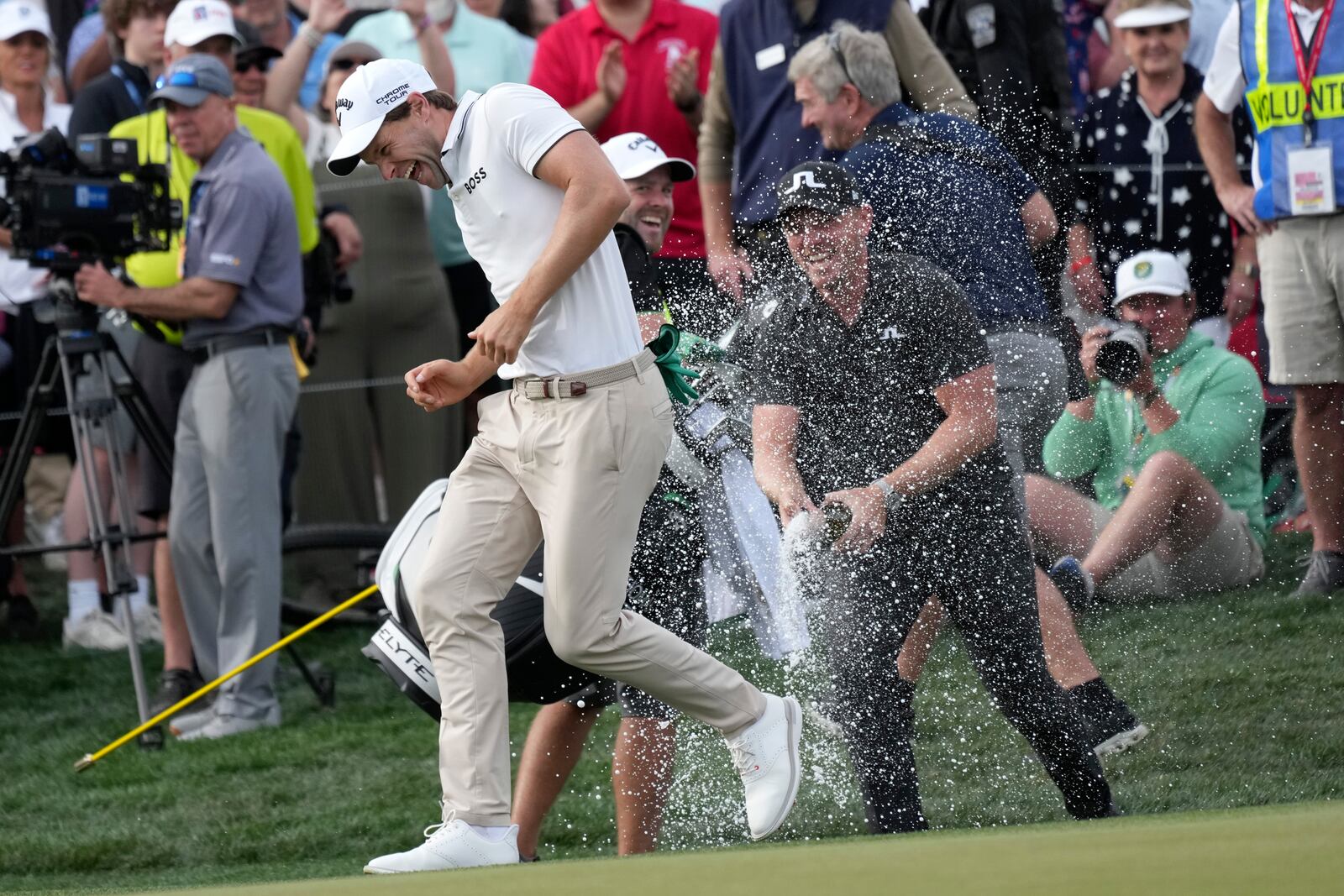 Thomas Detry, left, of Belgium, smiles as he celebrates after his win at the Phoenix Open golf tournament at TPC Scottsdale with fellow golfer Matt Wallace, right, of England, Sunday, Feb. 9, 2025, in Scottsdale, Ariz. (AP Photo/Ross D. Franklin)