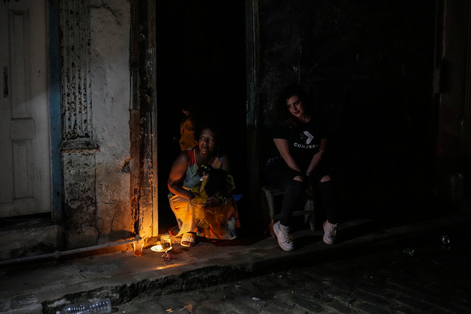 Residents pass the time during a blackout following the failure of a major power plant in Havana, Cuba, Saturday, Oct. 19, 2024. (AP Photo/Ramon Espinosa)