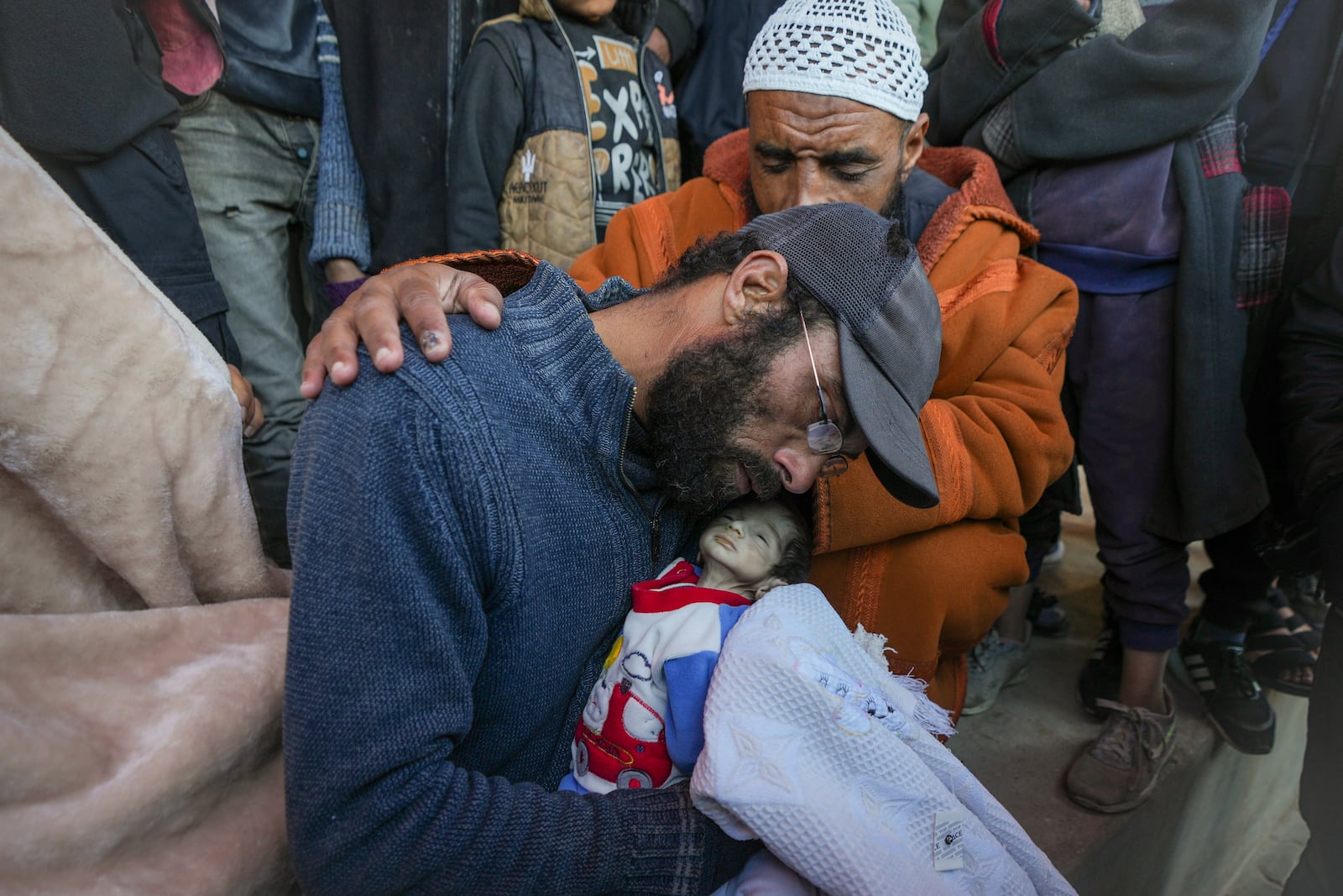 EDS NOTE: GRAPHIC CONTENT - Yehia al-Batran grieves as he holds the body of his 20-day-old son Jomaa, who died from hypothermia, at Al-Aqsa Martyrs Hospital in central Gaza, Sunday, Dec. 29, 2024. Jomaa's twin brother, Ali, remains in intensive care, as local health officials report at least three other infant deaths from the cold in recent weeks. (AP Photo/Abdel Kareem Hana)