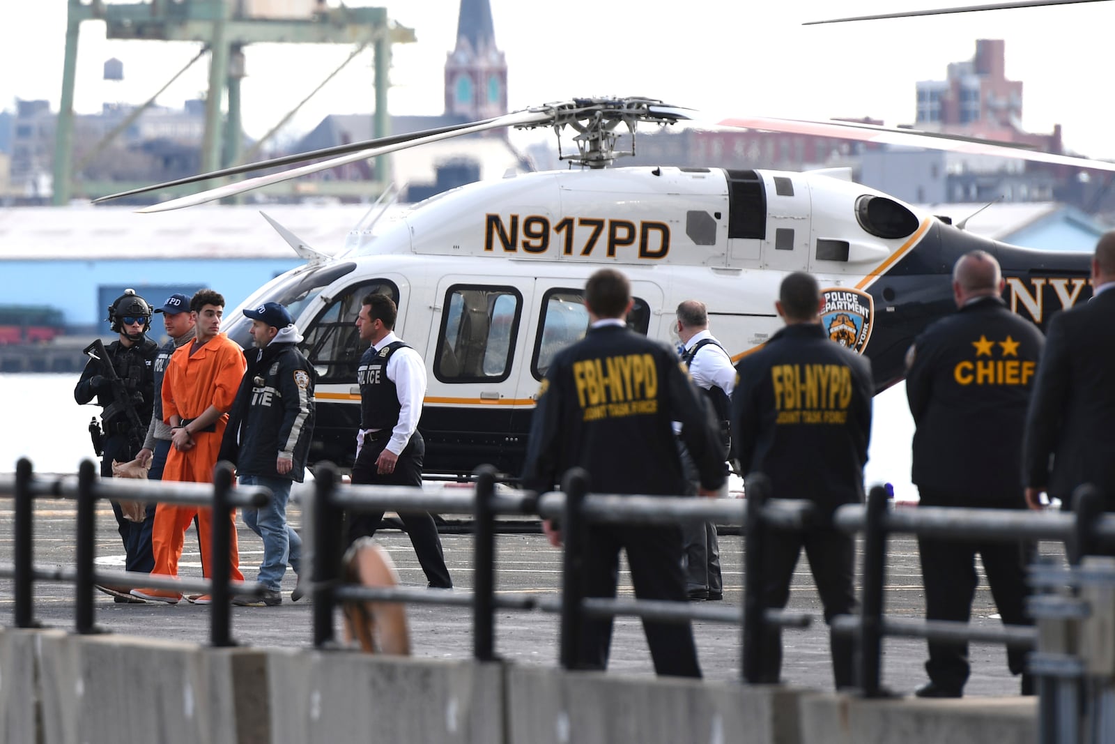 Luigi Mangione, a suspect in the fatal shooting of UnitedHealthcare CEO Brian Thompson, is escorted off of a helicopter by police, Thursday, Dec. 19, 2024, in New York. (AP Photo/Pamela Smith)