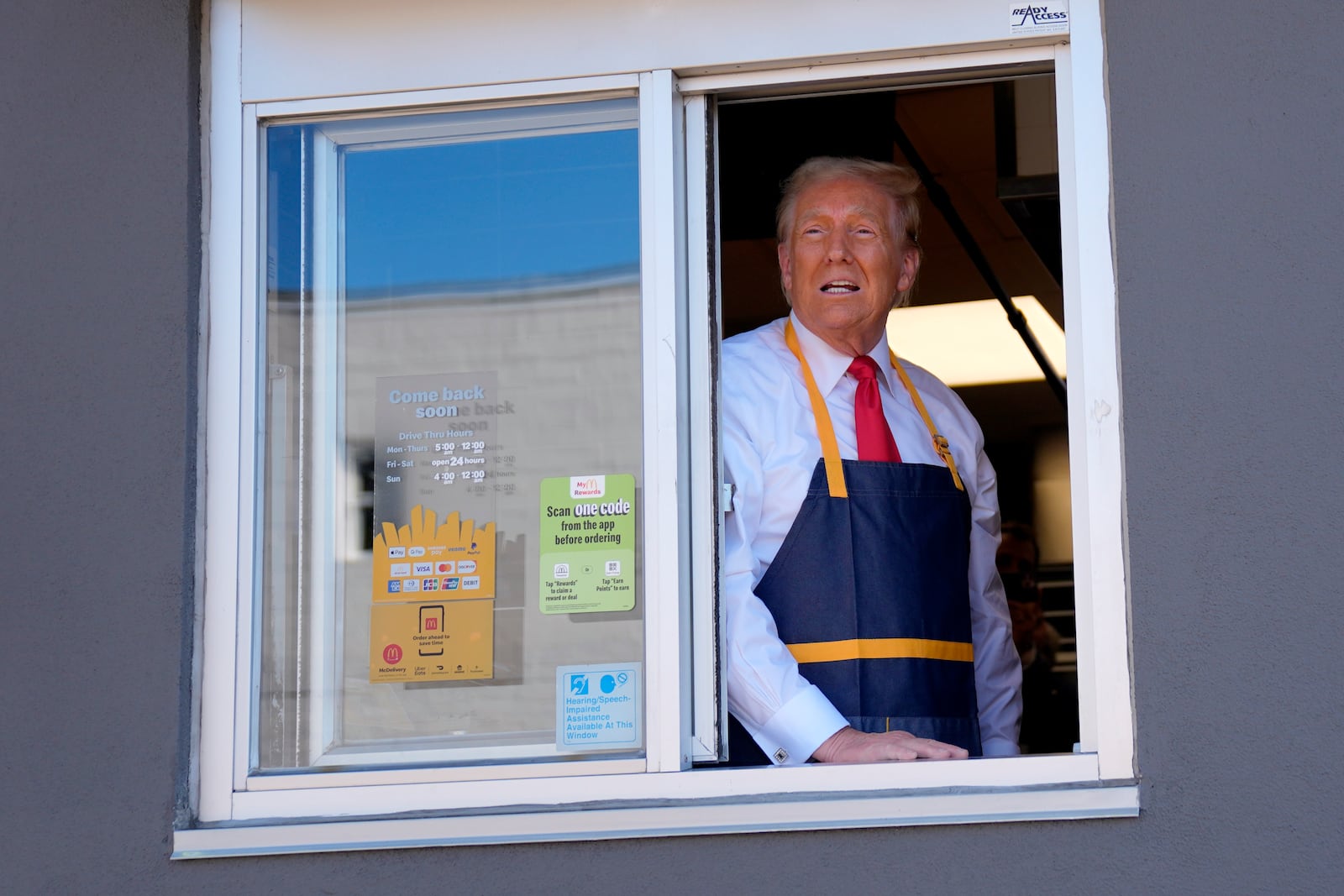 Republican presidential nominee former President Donald Trump stands at the drive-thru window during a campaign stop at a McDonald's, Sunday, Oct. 20, 2024, in Feasterville-Trevose, Pa. (AP Photo/Evan Vucci)