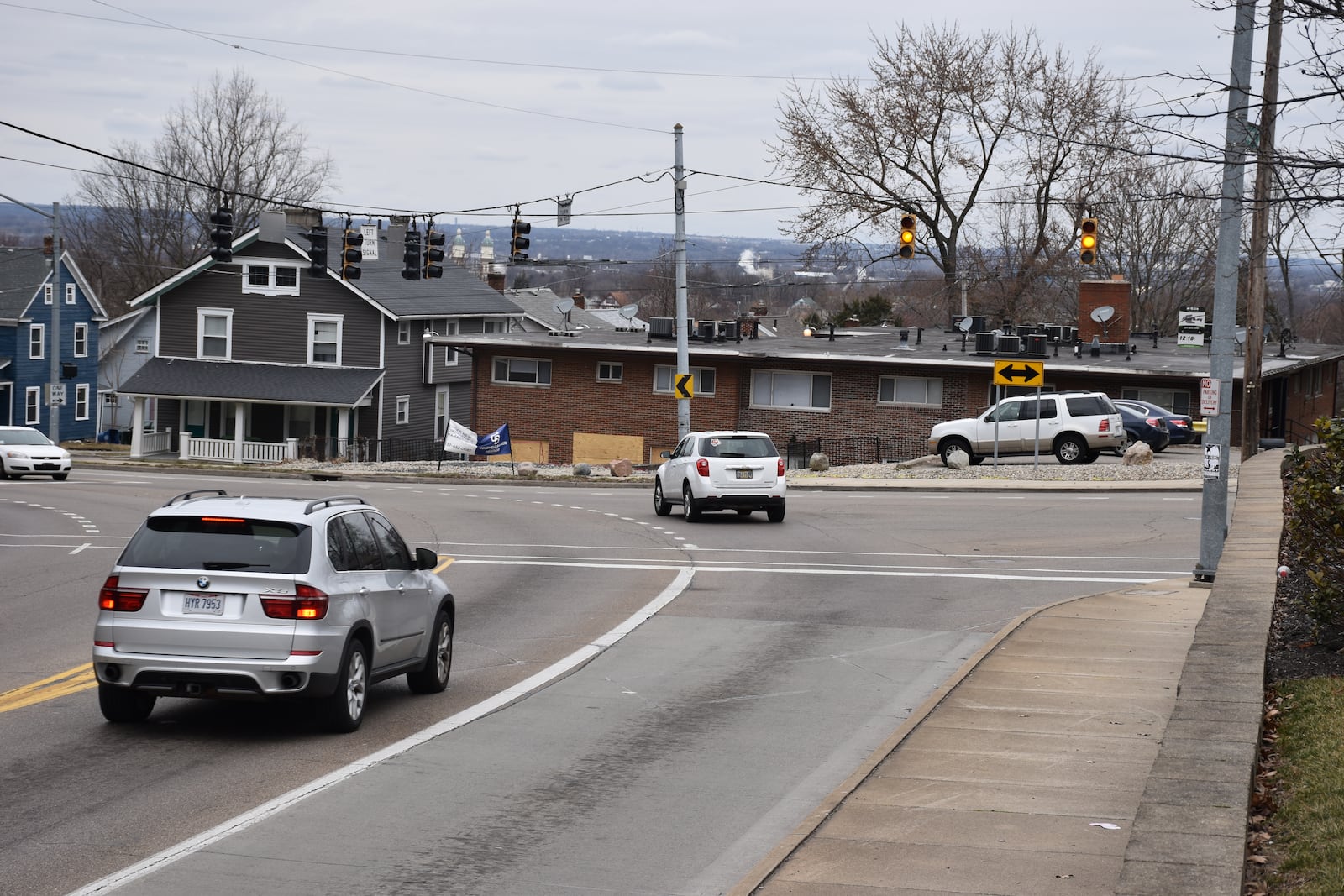 Cars drive north at the intersection of Wayne and Wilmington Avenues right by the apartment building at 2308 Wayne Ave., where multiple vehicles have crashed into the property. CORNELIUS FROLIK / STAFF