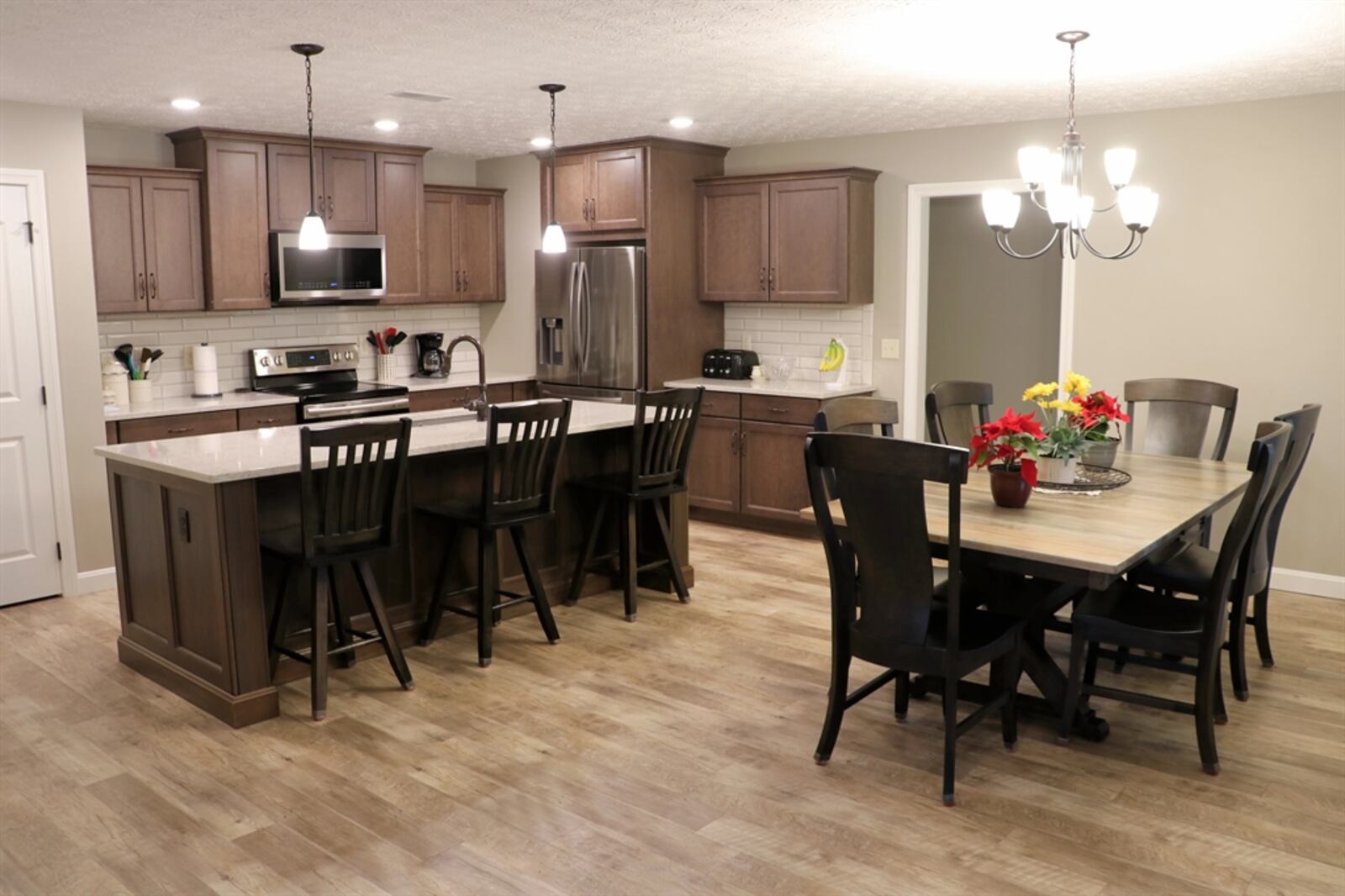 Two walls of cabinetry surround upgraded appliances that include a range, microwave and refrigerator.