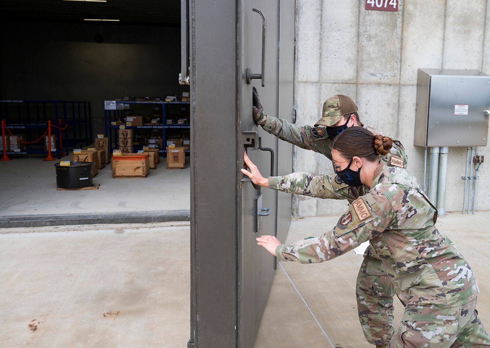 Staff Sgt. Jacklyn Hill and Senior Airman Ryan Klingbeil, 88th Operations Support Squadron Munitions Flight inspectors, close a large, armored door to one of the new explosives-storage igloos Nov. 17 at Wright-Patterson Air Force Base. The $6.5 million construction project greatly increased the squadron’s munitions capabilities while reducing its footprint. U.S. AIR FORCE PHOTO/R.J. ORIEZ