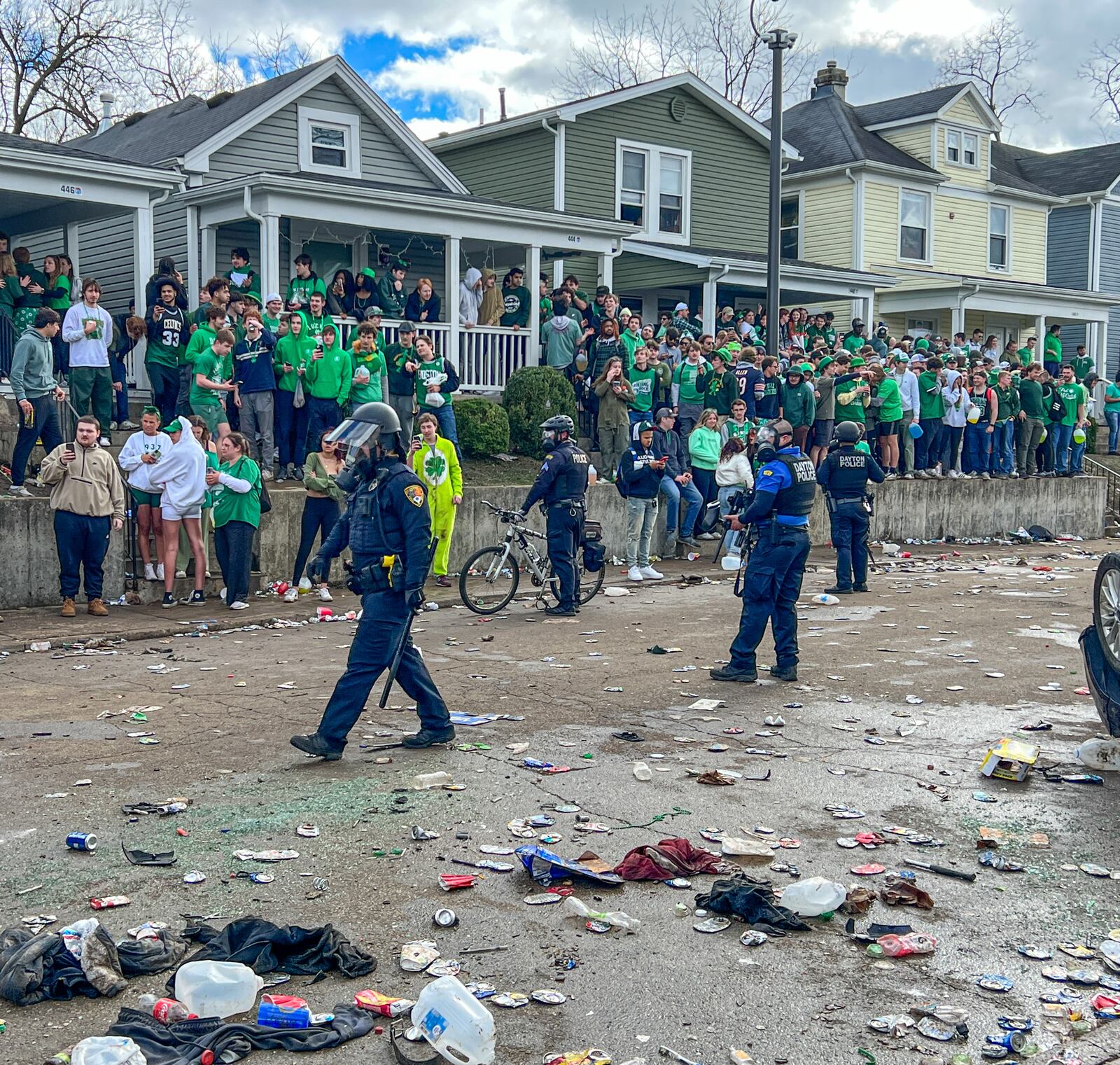 Police officers are shown on the littered 400 block of Lowes Street at the University of Dayton as crowds gather on sidewalks and yards after a party turned into a disturbance on Saturday, March 25, 2023. Some people overturned a vehicle, and at least six people were arrested, according to university officials. KEEGAN GUPTA/CONTRIBUTED