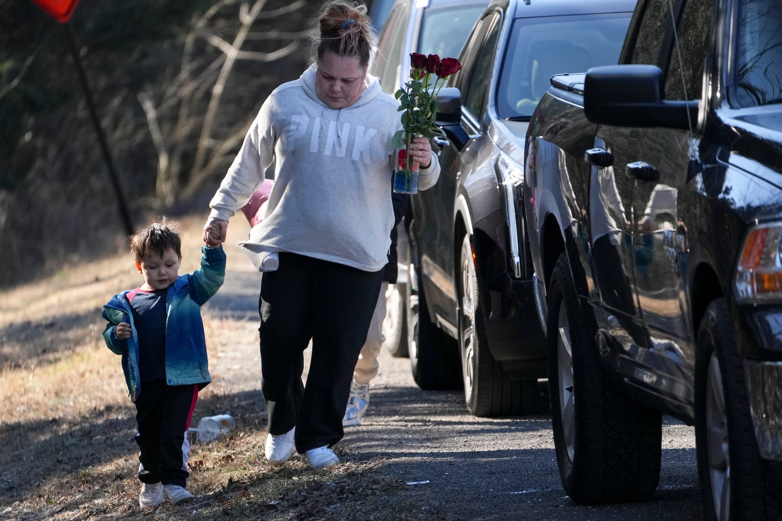 Amber Lopez, arrives with her son Jordan, 3, to leave flowers at a memorial for victims of a shooting at Antioch High School, Thursday, Jan. 23, 2025, in Nashville, Tenn. (AP Photo/George Walker IV)