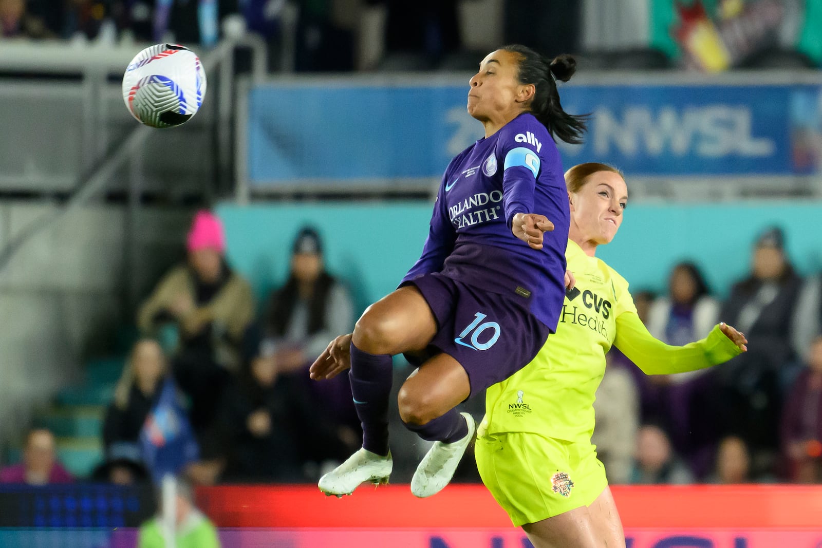 Orlando Pride forward Marta (10) leaps into the air to make a play on a ball in front of Washington Spirit midfielder Hal Hershfelt, right, during the first half of the NWSL championship at CPKC Stadium, Saturday, Nov. 23, 2024, in Kansas City, Mo. (AP Photo/Reed Hoffmann)