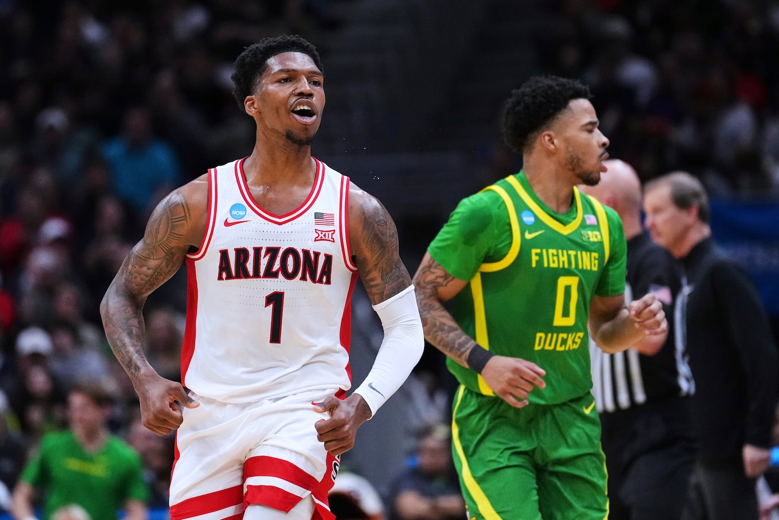 Arizona guard Caleb Love (1) reacts as Oregon guard Ra'Heim Moss (0) looks on during the first half in the second round of the NCAA college basketball tournament, Sunday, March 23, 2025 in Seattle. (AP Photo/Lindsey Wasson)