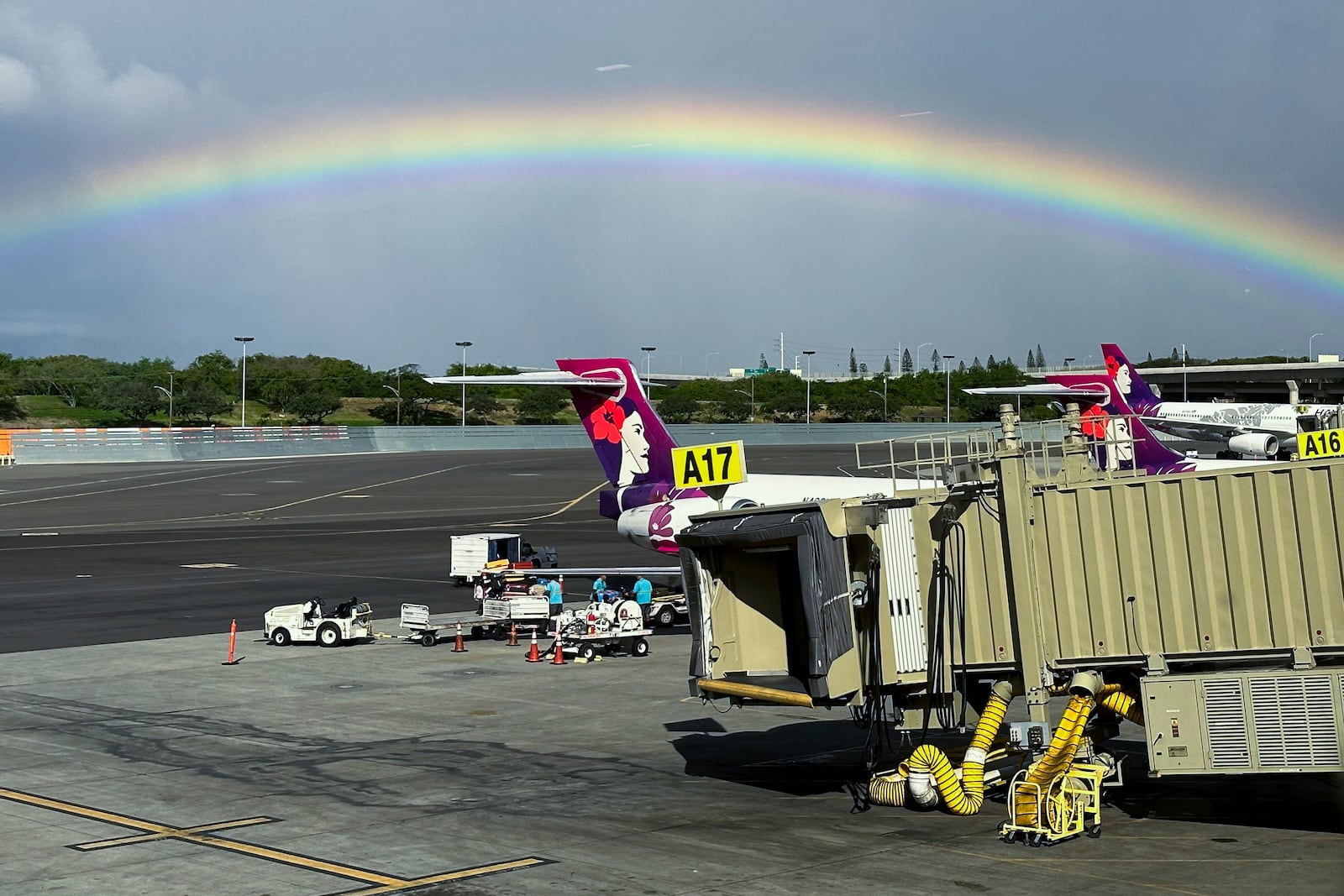 In this image taken through a window, a rainbow appears in the sky on Dec. 23, 2023, in Honolulu. (AP Photo/Audrey McAvoy)