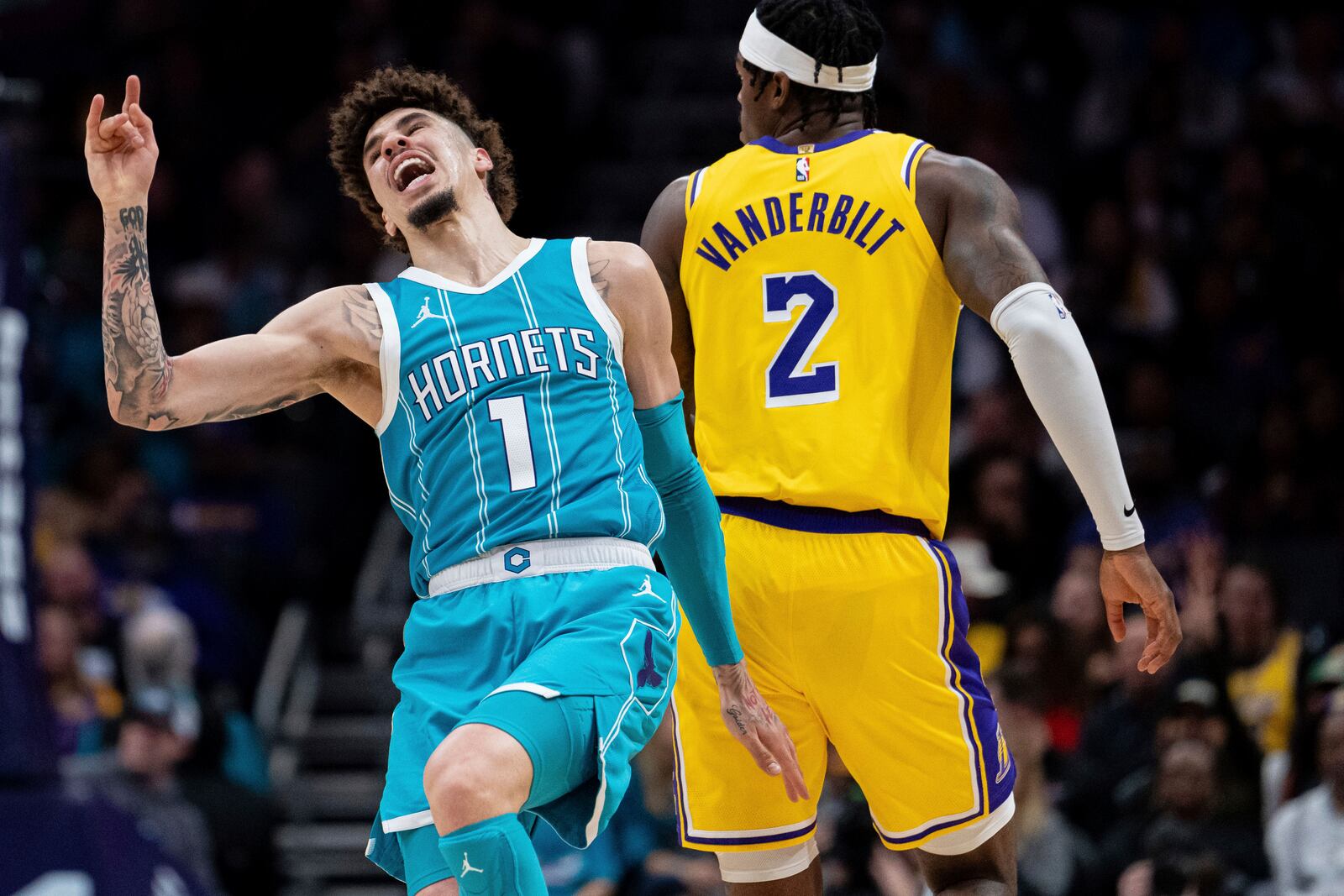 Charlotte Hornets guard LaMelo Ball (1) reacts as he trips over Los Angeles Lakers forward Jarred Vanderbilt (2) during the first half of an NBA basketball game Monday, Jan. 27, 2025, in Charlotte, N.C. (AP Photo/Jacob Kupferman)