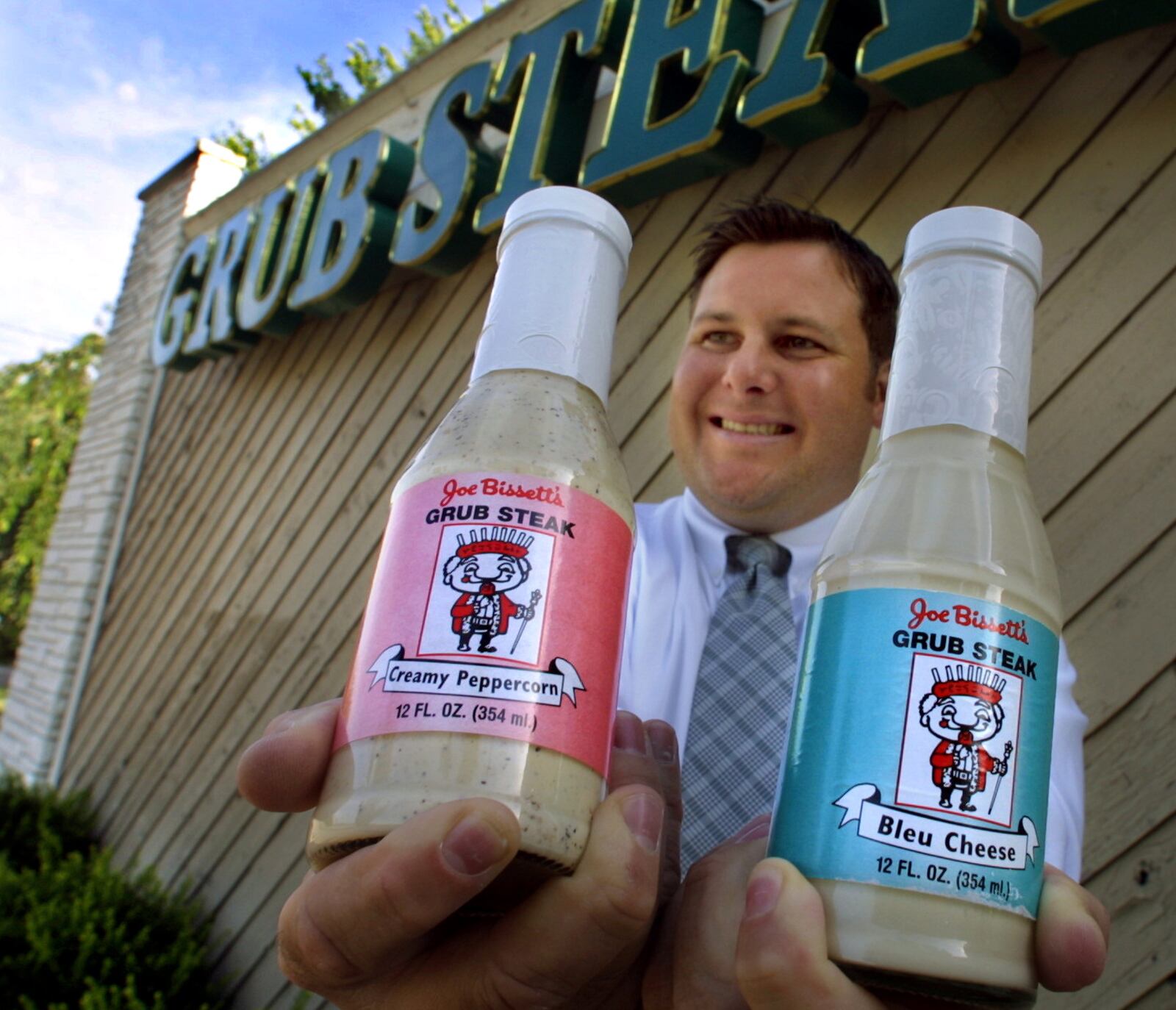 Clay Bissett, owner of Grub Steak II, displays 2 of the types of their salad dressing that were on sale in the restaurants and also in Kroger, Cub Foods and IGA.