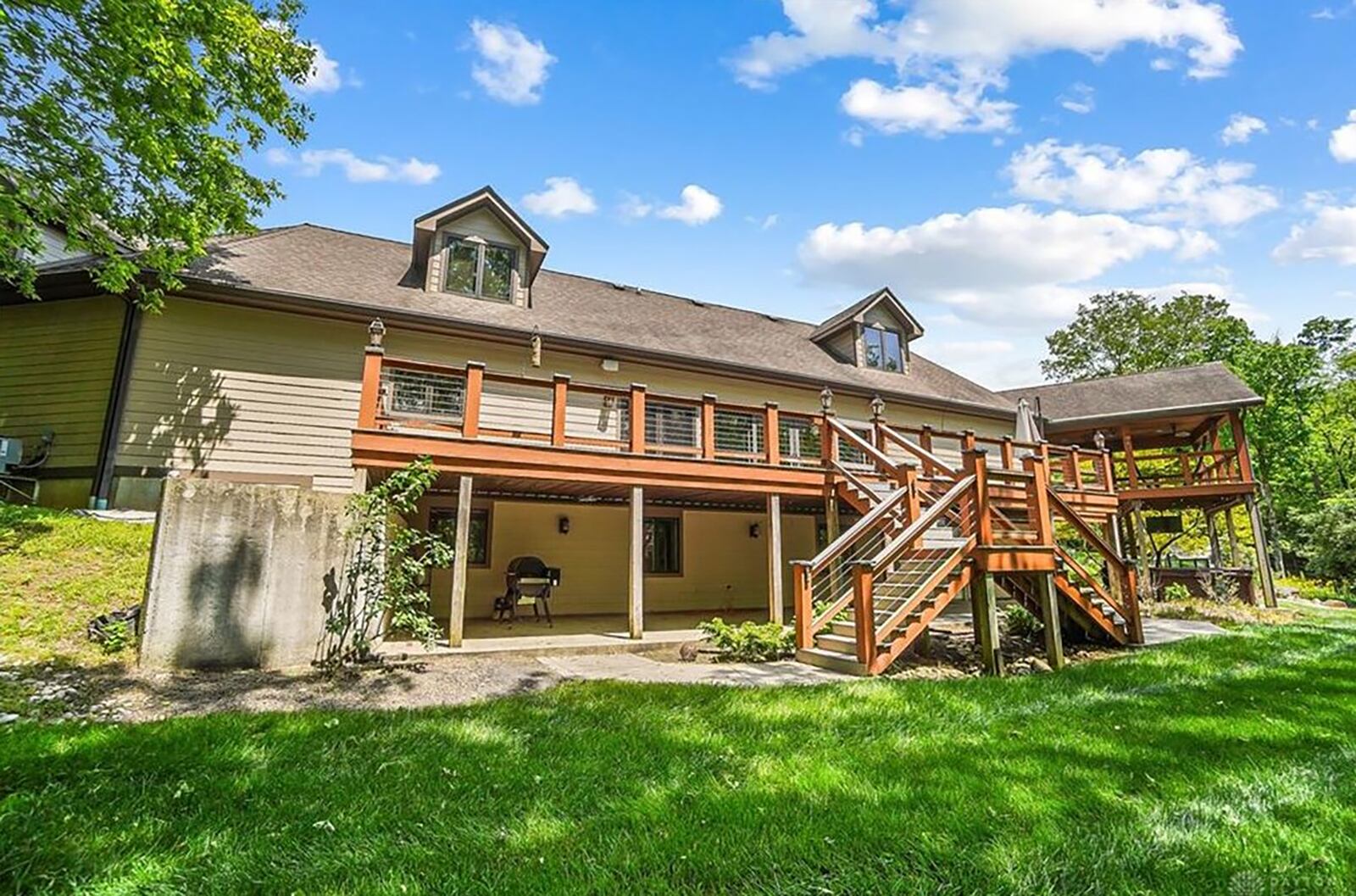 The back of the home has a two level deck. The basement walks out to a covered section with a hot tub and grill. There is an additional covered patio on the upper level.