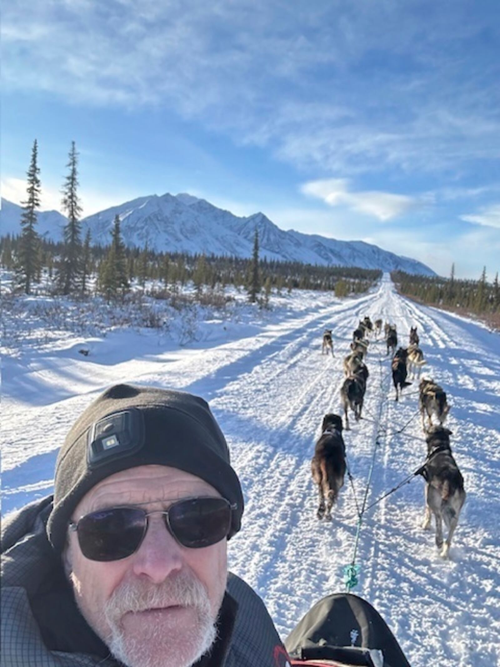 In this undated photo provided by Jeff King, the four-time Iditarod Trail Sled Dog Race winner takes a selfie with his dog team as they approach Mount McKinley, formerly known as Denali, near Denali National Park and Preserve, Alaska. (Jeff King via AP)