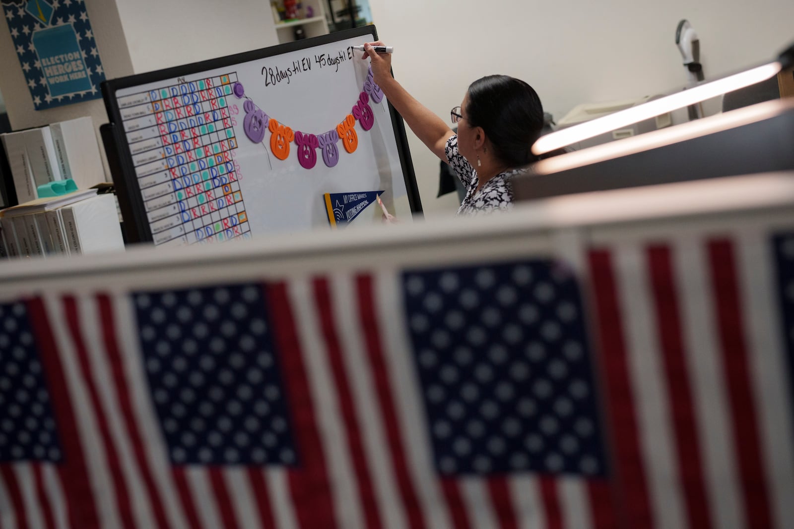 Office assistant Shawna Johnson marks a countdown until election day on a whiteboard at the Washoe County Registrar of Voters office, Saturday, Sept. 21, 2024, in Reno, Nev. (AP Photo/John Locher)