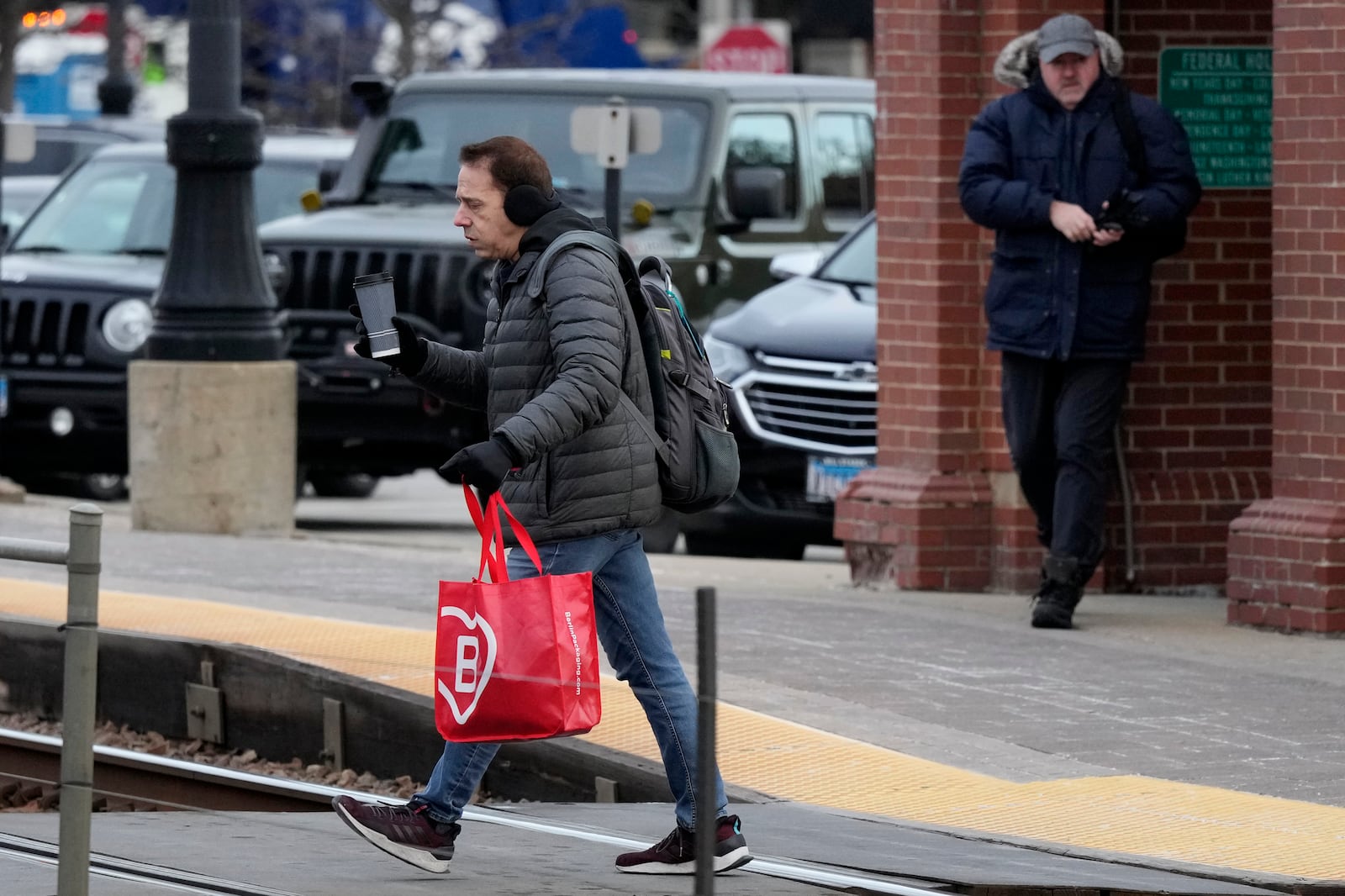 A commuter walks to the Metro train station during cold weather in Northbrook, Ill., Thursday, Dec. 12, 2024. (AP Photo/Nam Y. Huh)