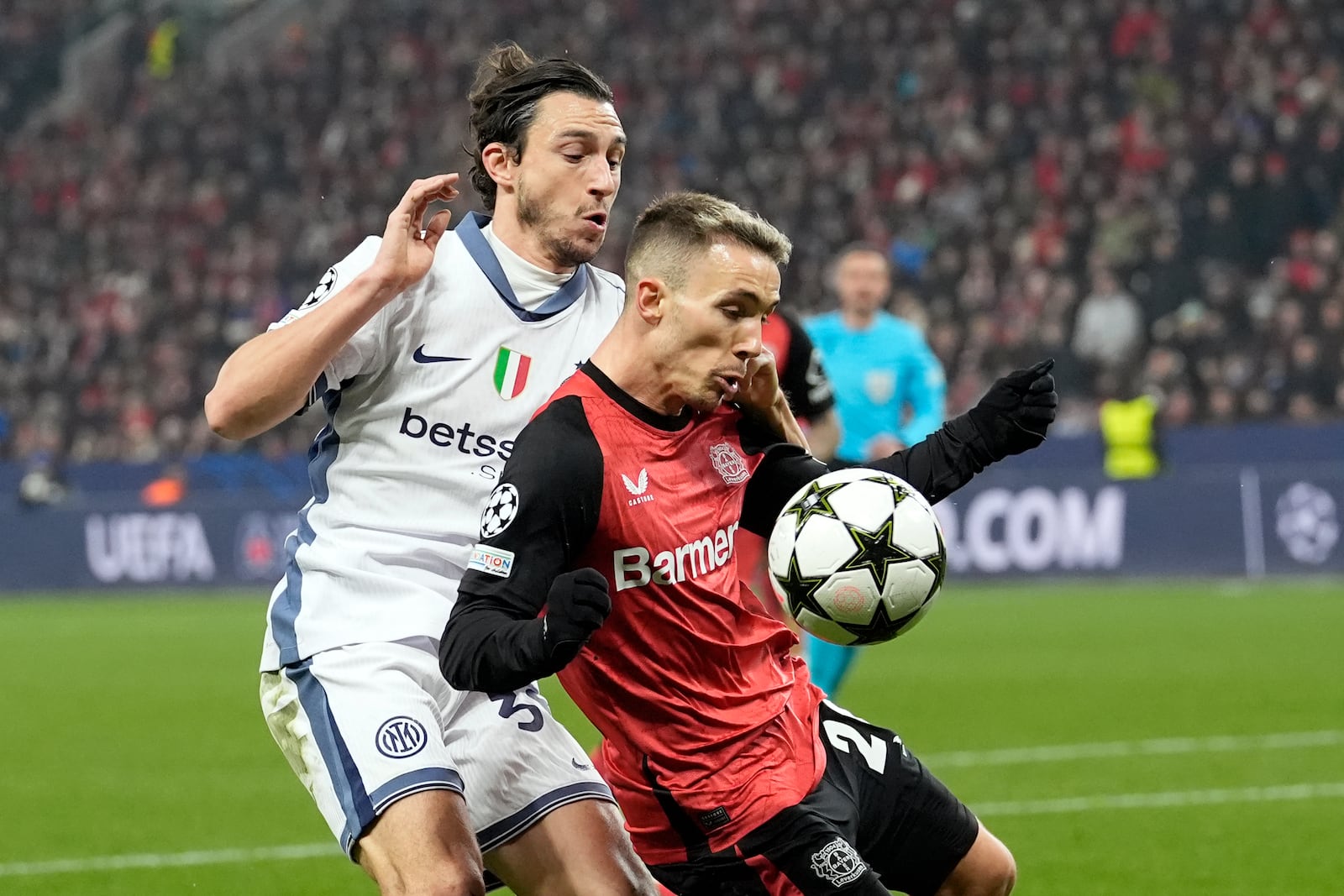 Leverkusen's Alex Grimaldo shields the ball from Inter Milan's Matteo Darmian during the Champions League opening phase soccer match between Bayer Leverkusen and Inter Milan at the BayArena in Leverkusen, Germany, Tuesday Dec. 10, 2024. (AP Photo/Martin Meissner)