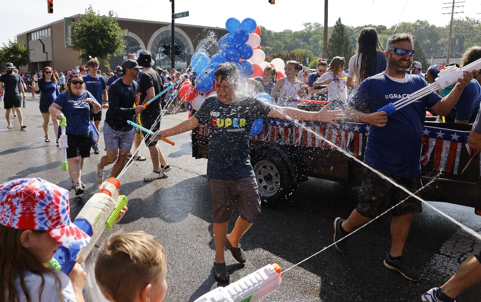 Parade attendees get drenched during Franklin's Independence Day Parade, known as "The Wettest Parade in Ohio", Tuesday, July 4, 2023 on Main Street in Franklin. Wet zones are set up at each intersection for a friendly water fight with many parade floats and fire trucks blasting water at bystanders. NICK GRAHAM/STAFF