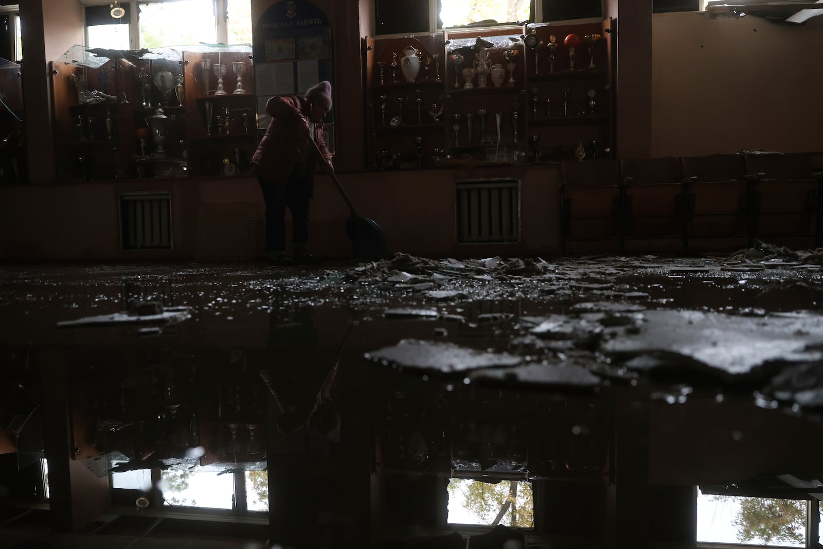 A woman clear the rubble inside a sports center damaged by a Russian strike in Zaporizhzhia, Ukraine, November 11, 2024. (AP Photo/Kateryna Klochko)