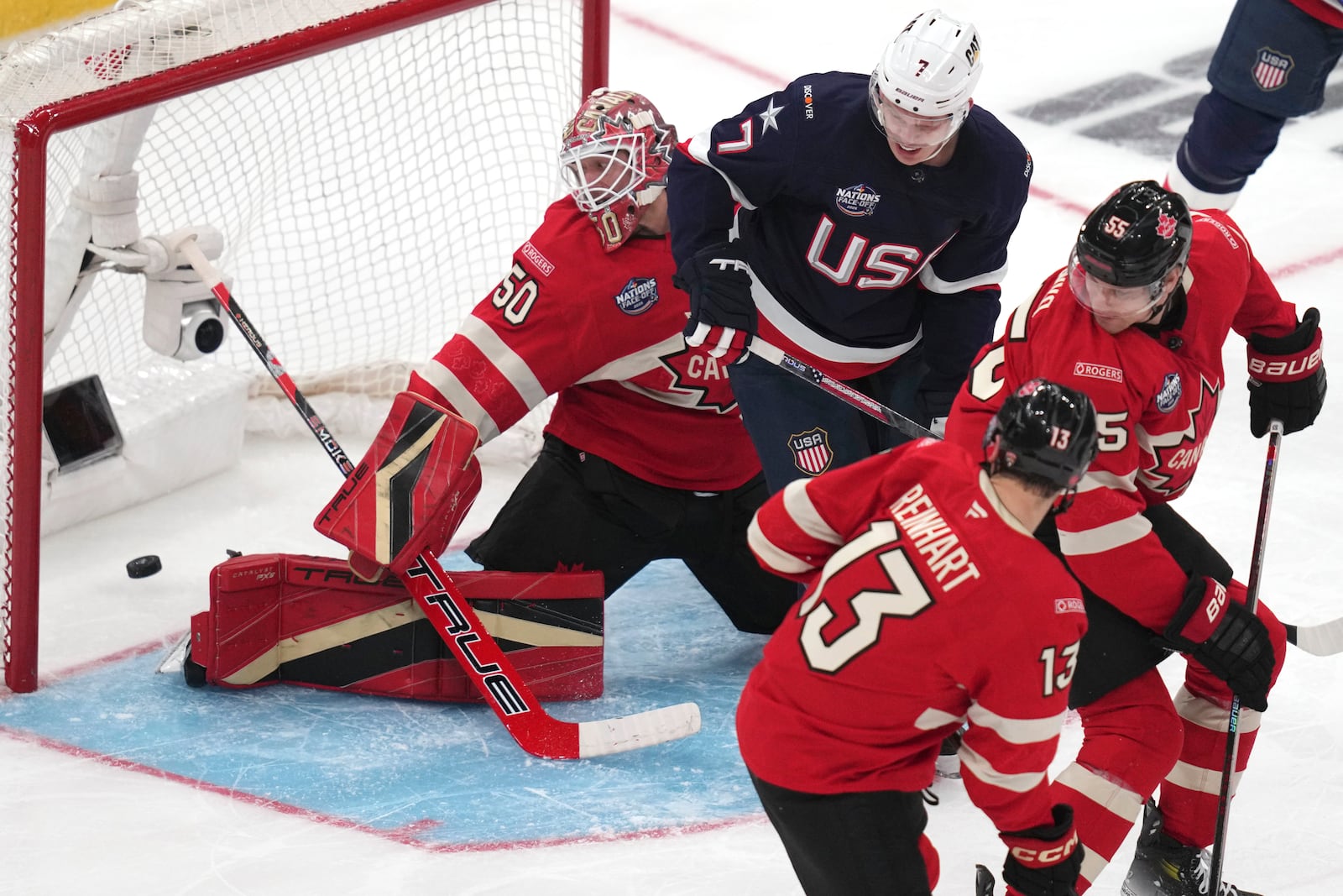 Canada goalie Jordan Binnington, left, looks back at the puck on a goal by United States' Jake Sanderson during the second period of the 4 Nations Face-Off championship hockey game, Thursday, Feb. 20, 2025, in Boston. (AP Photo/Charles Krupa)