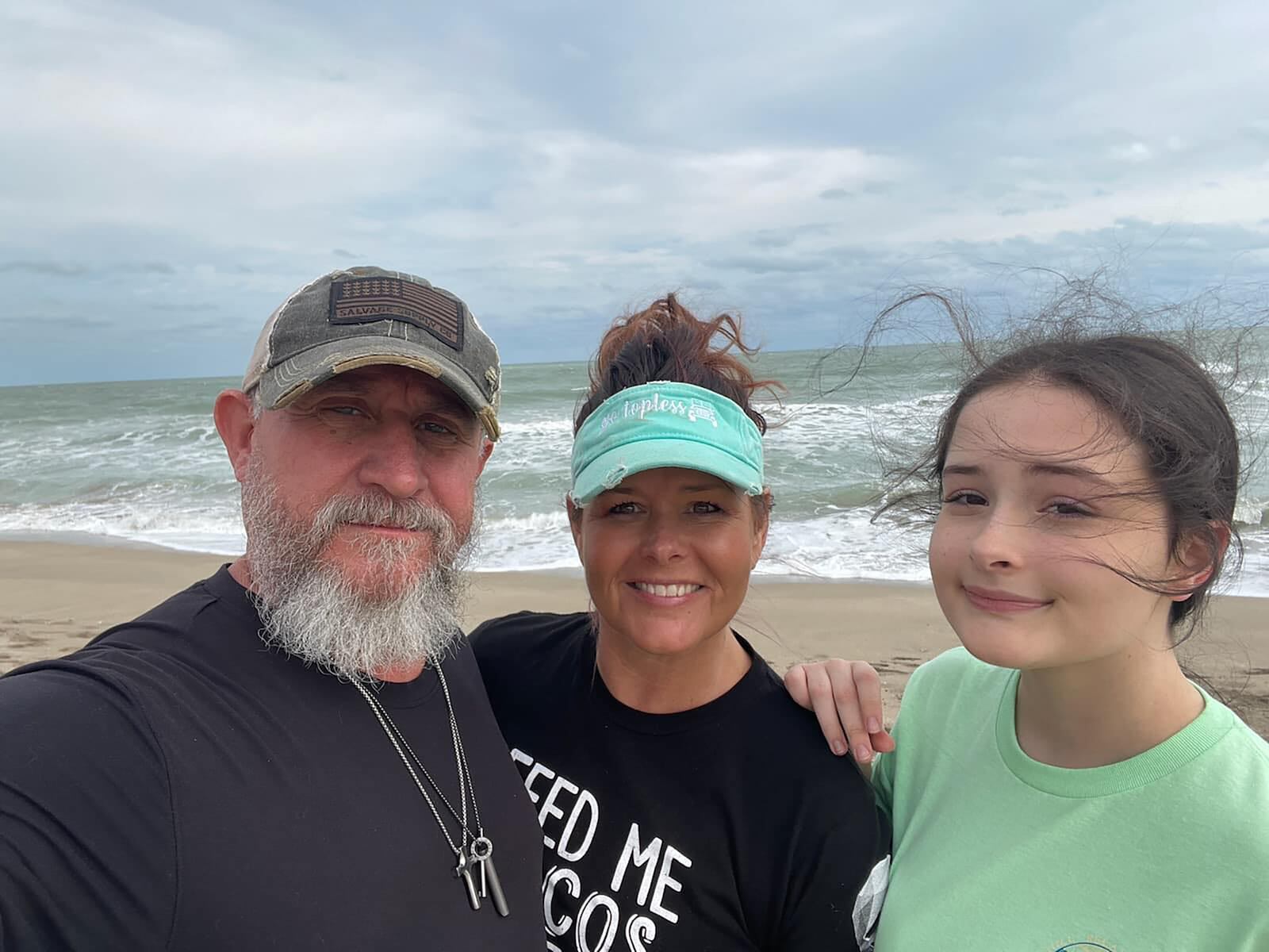 Chris (left) and Angie (center) McConnell enjoy a beach vacation with Angie's youngest daughter, Anna, in 2022. Anna is now 17 years old.