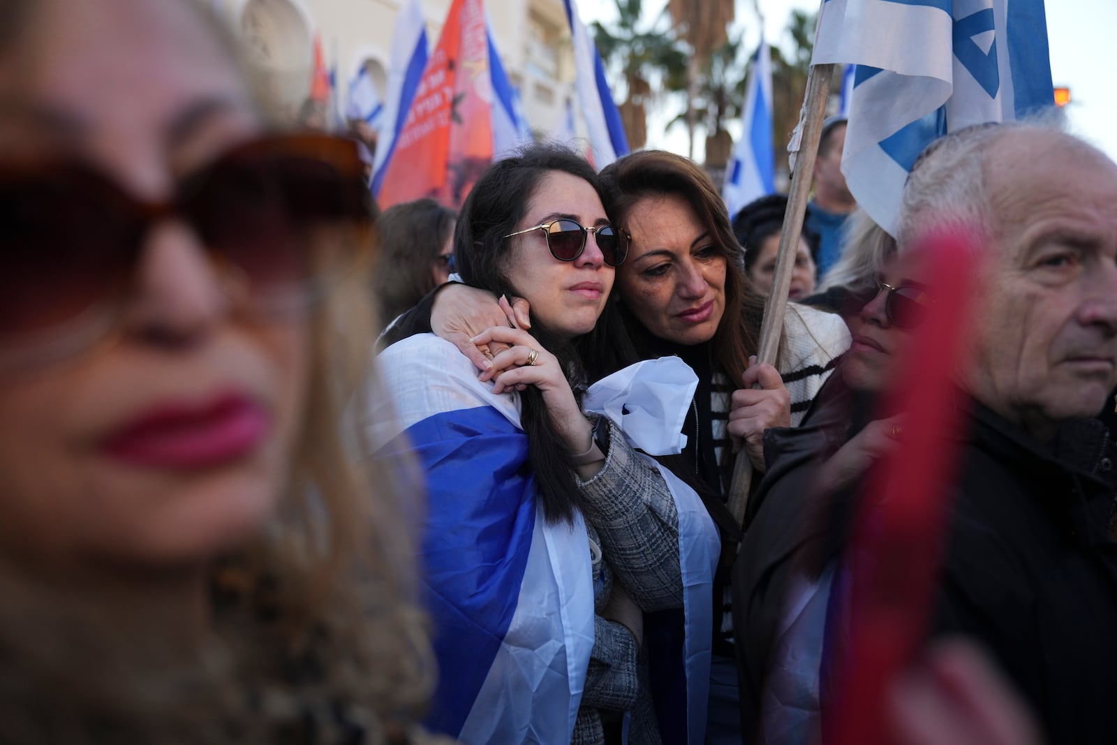 Mourners react as the convoy carrying the coffins of slain hostages Shiri Bibas and her two children, Ariel and Kfir, passes by during their funeral procession in Rishon Lezion, Israel, Wednesday, Feb. 26, 2025. The mother and her two children were abducted by Hamas on Oct. 7, 2023, and their remains were returned from Gaza to Israel last week as part of a ceasefire agreement with Hamas. (AP Photo/Ariel Schalit)