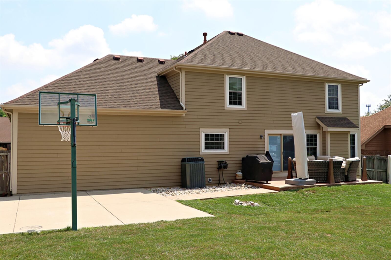 The privacy-fence surrounded back yard has a stamped concrete patio and a concrete basketball half-court. CONTRIBUTED PHOTO BY KATHY TYLER