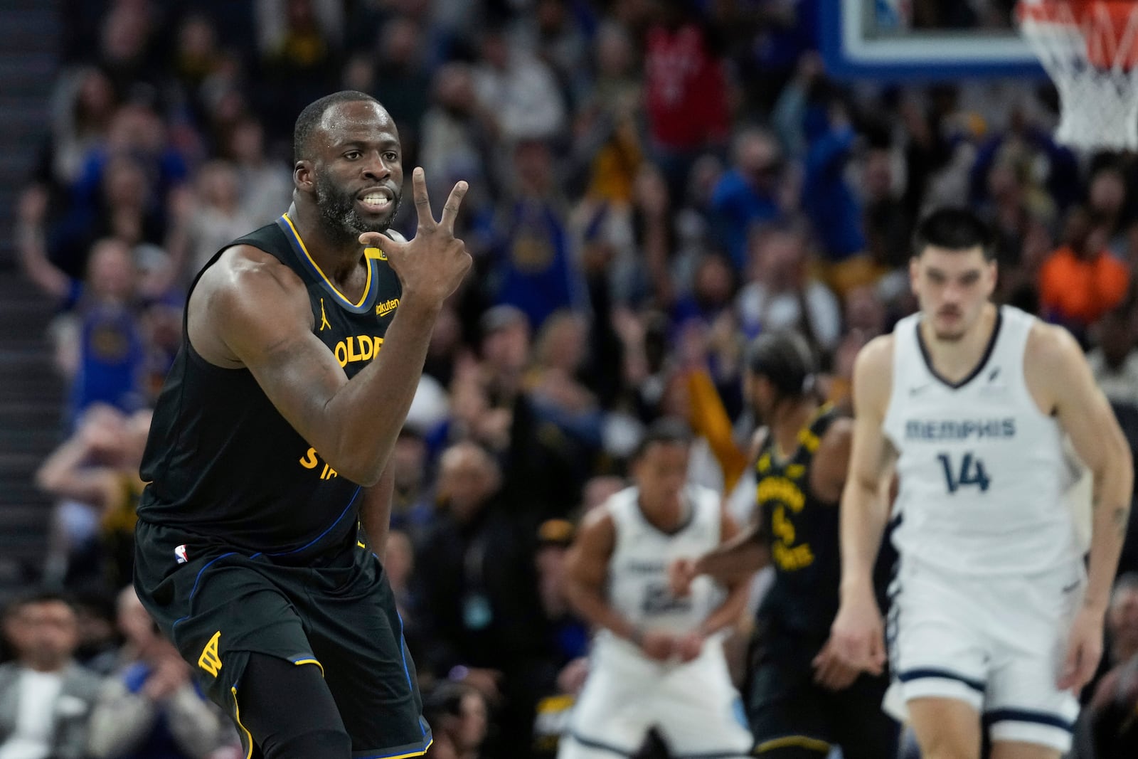 Golden State Warriors forward Draymond Green, left, reacts after making a 3-point basket during the second half of an Emirates NBA Cup basketball game against the Memphis Grizzlies, Friday, Nov. 15, 2024, in San Francisco. (AP Photo/Godofredo A. Vásquez)